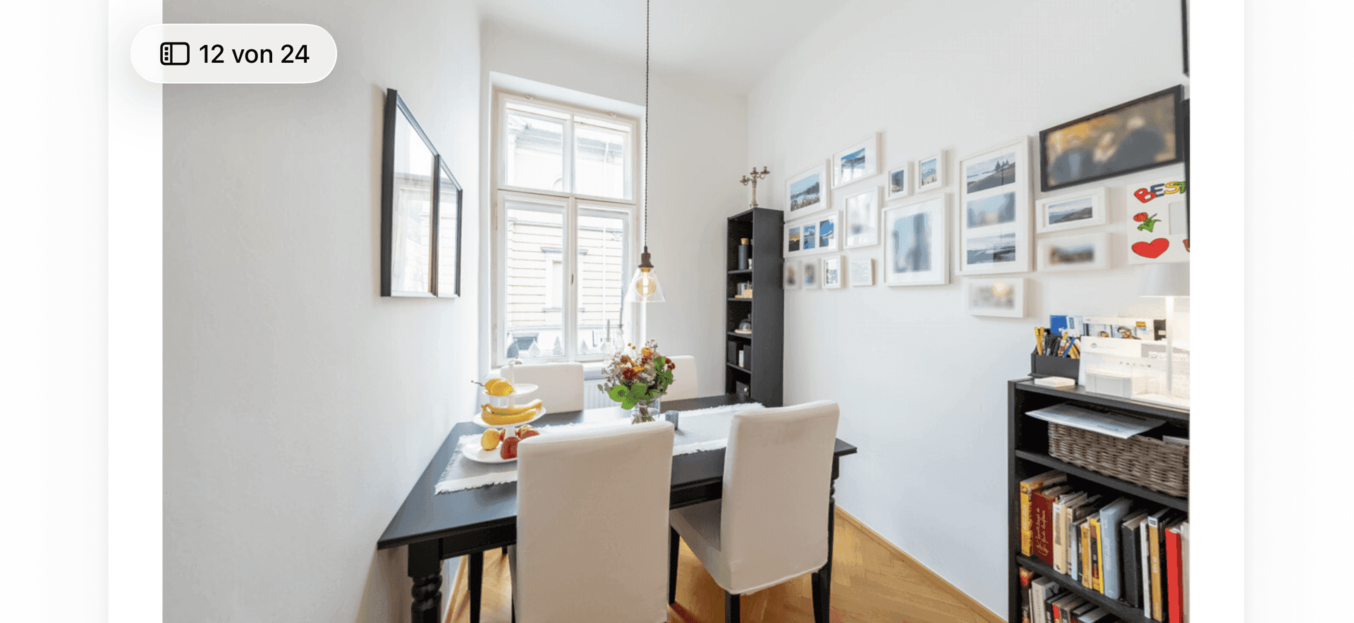 Kleiner Essbereich mit Esstisch, Stühlen und einer Wandgalerie.