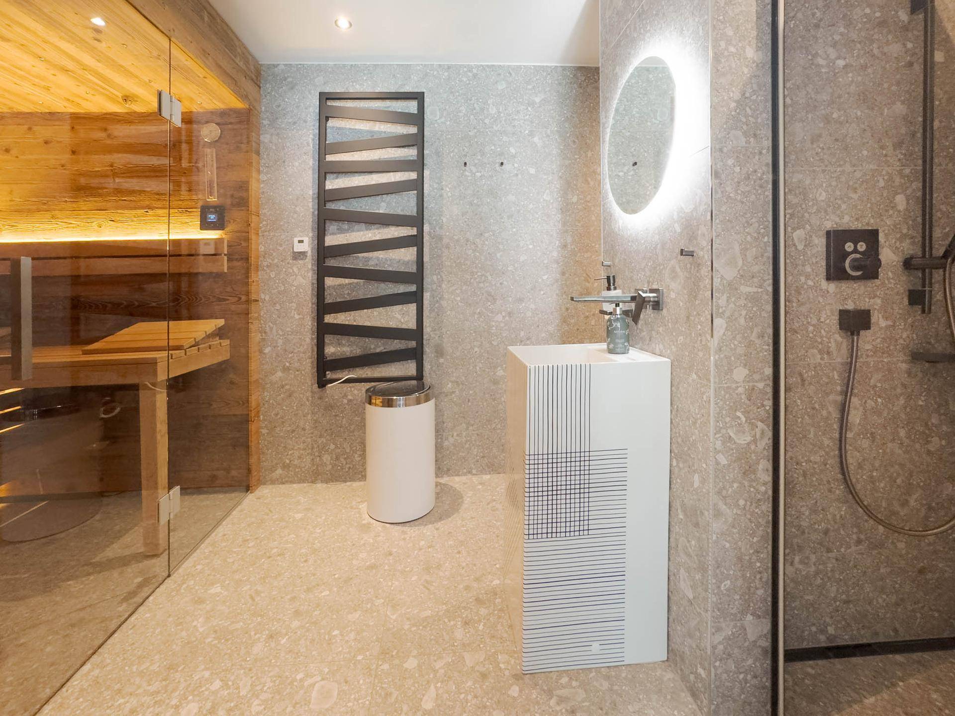Modernes Badezimmer mit Sauna, großformatigen Fliesen und beheiztem Handtuchhalter.
