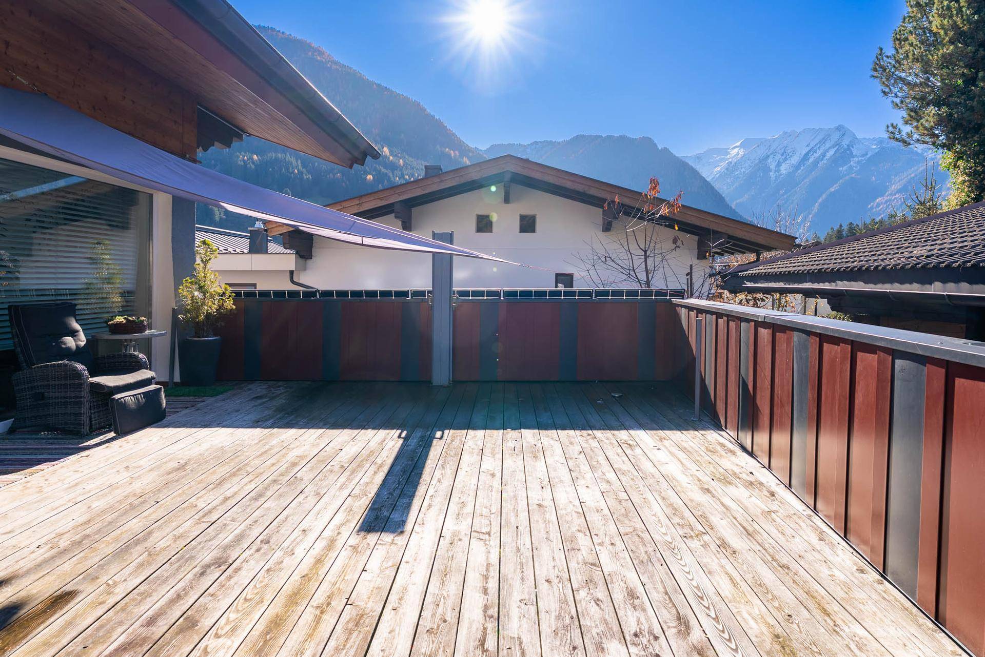 Große Holzterrasse mit Bergblick, ideal für Entspannung und Outdoor-Aktivitäten.