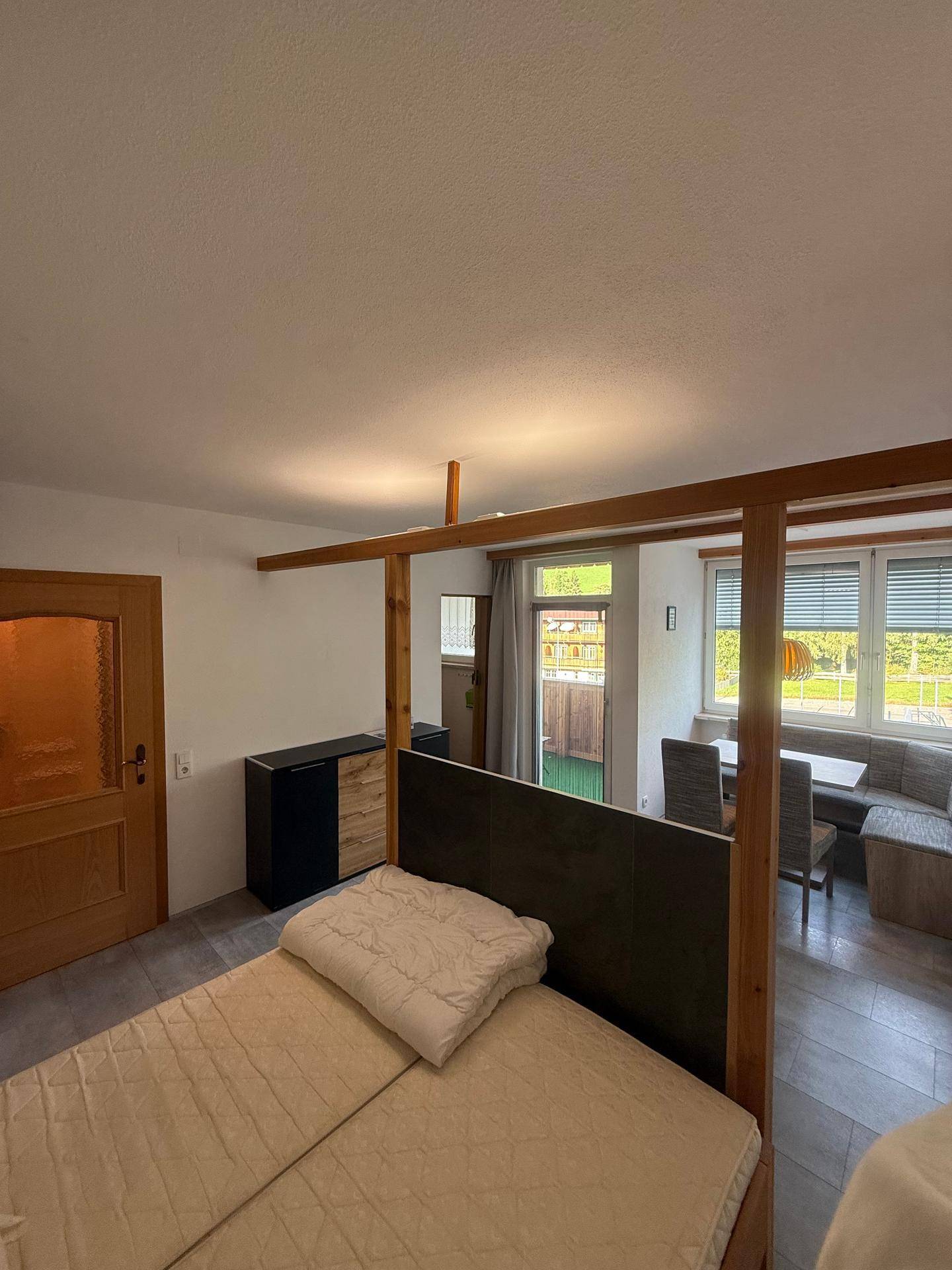 Studio-Apartment mit Schlafbereich, Essplatz und Blick ins Grüne.