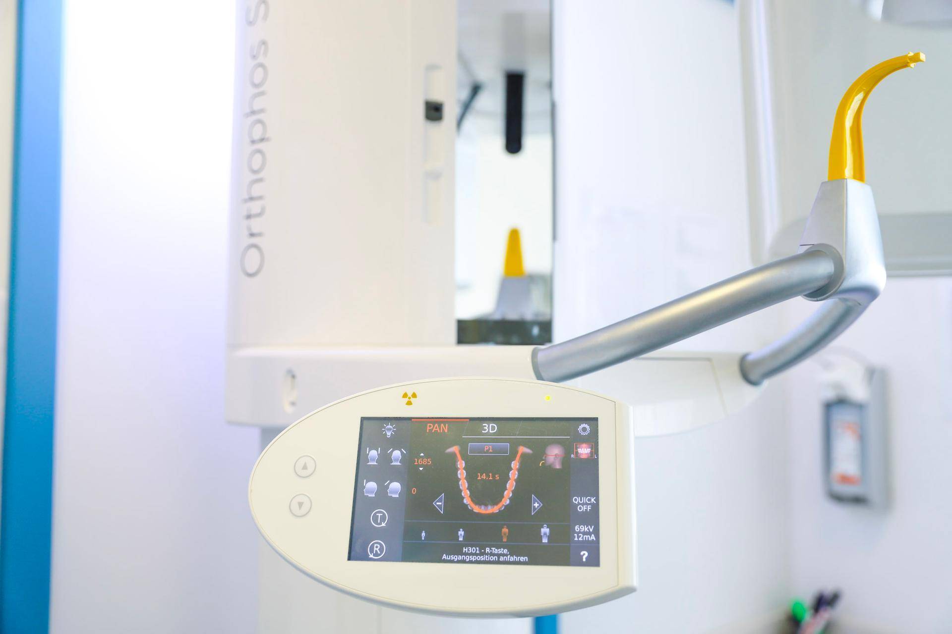 Nahaufnahme des "Orthophos SL" Röntgengeräts mit Touchscreen und gelbem Positionierungsarm.