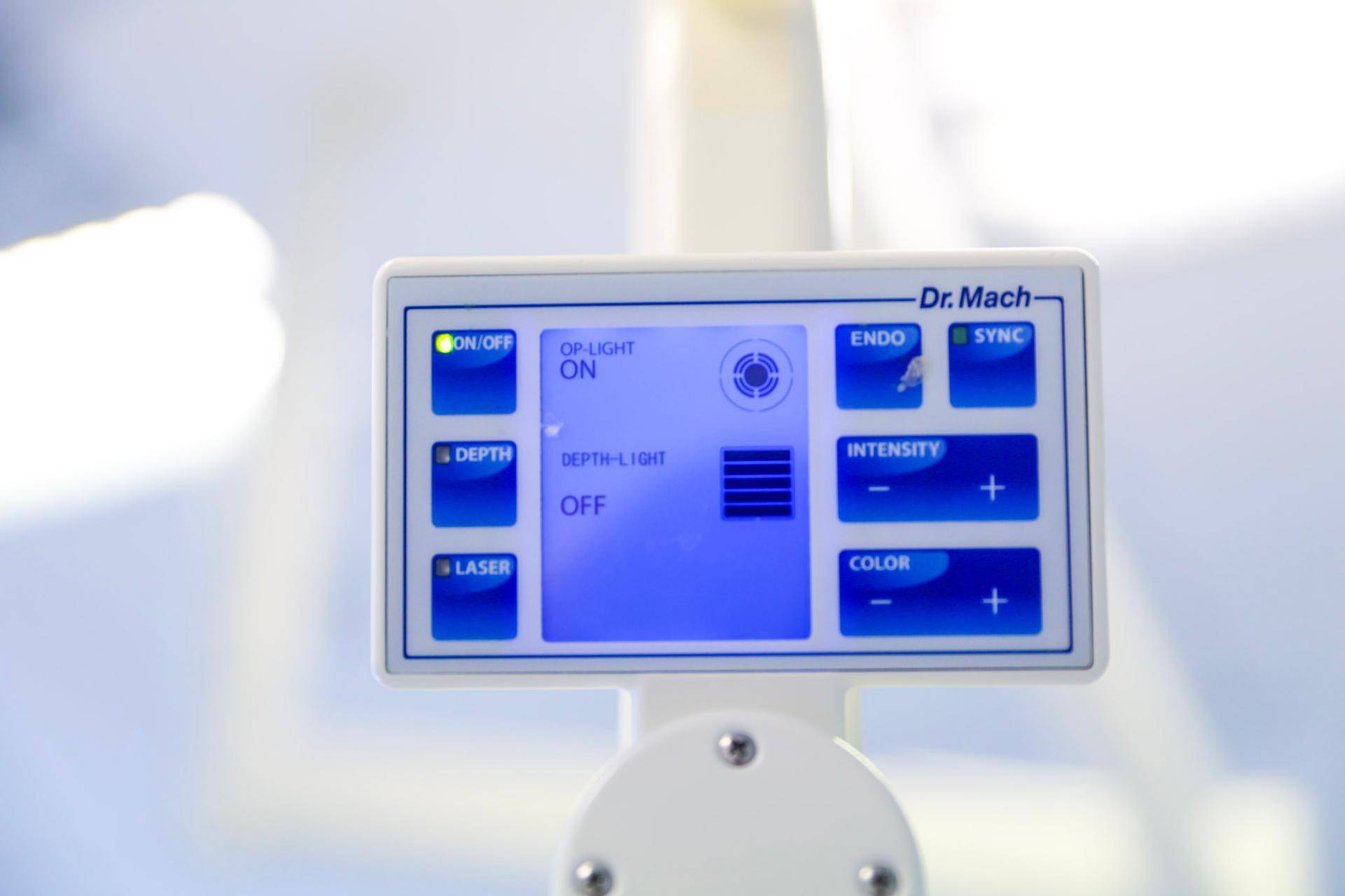 Bedienfeld einer Operationsleuchte mit digitalen Anzeigen und blauen Tasten für verschiedene Einstellungen.