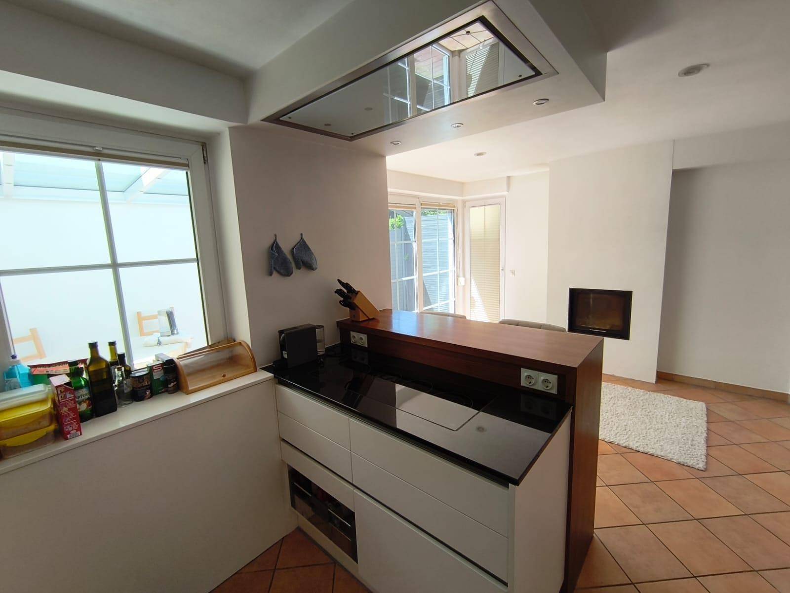 Offener Wohnbereich mit Küche, Bar und Kamin, hell und geräumig.