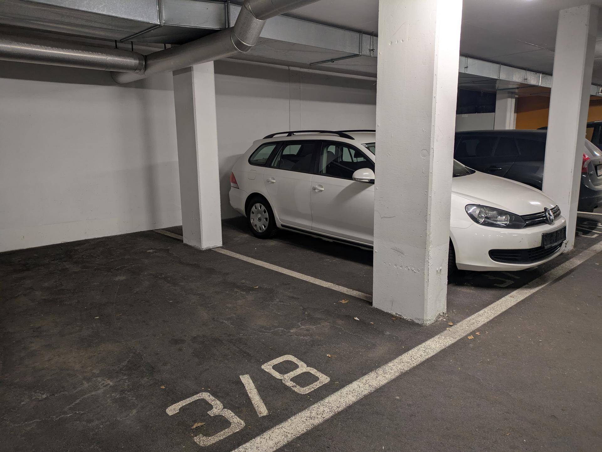 Parkplatz in einer Tiefgarage mit markierter Stellplatznummer und Betonstützen.