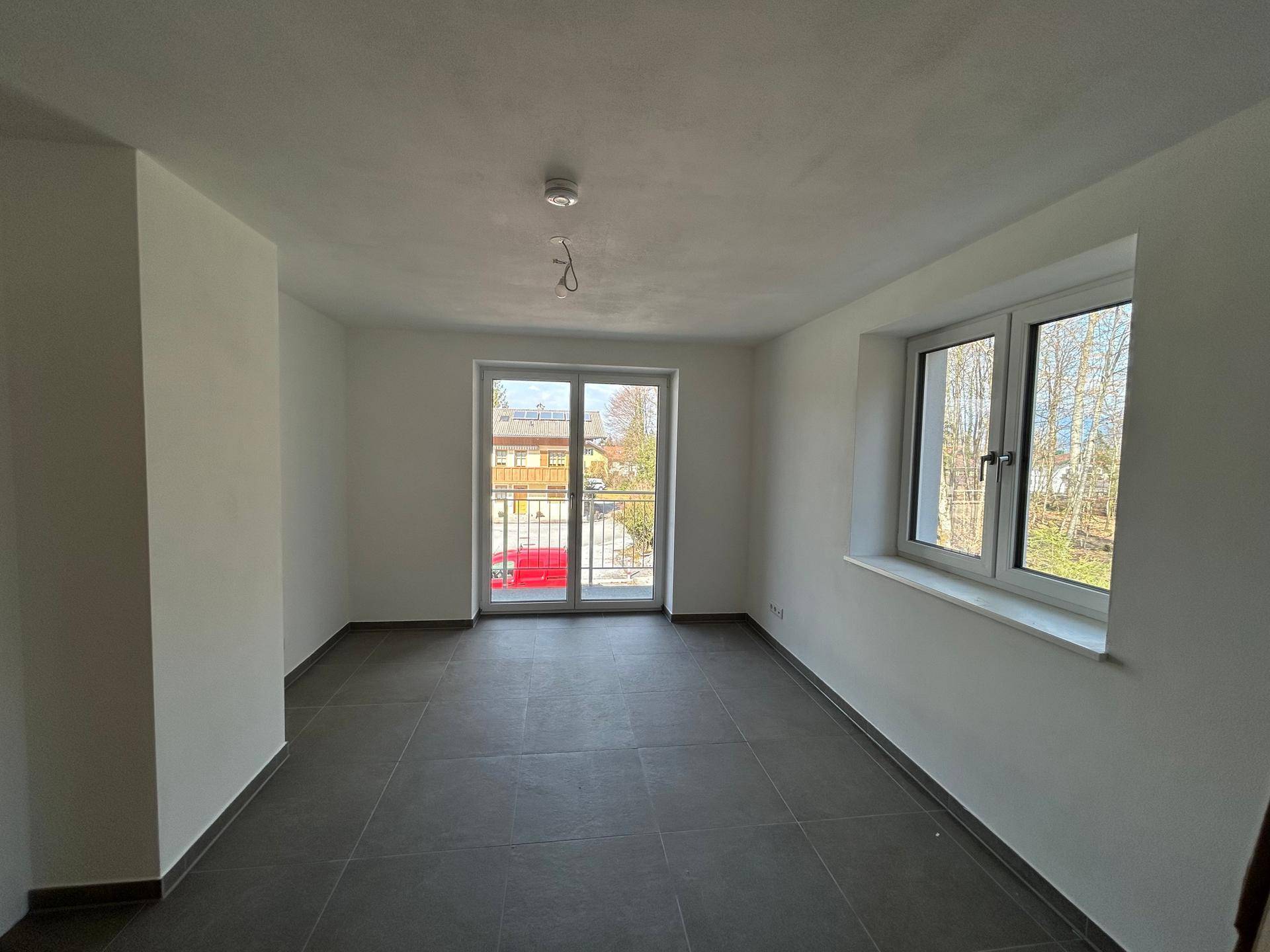 Geräumiger Raum mit Balkonzugang und einem zusätzlichen Fenster, das viel Licht bietet und den Raum erhellt.