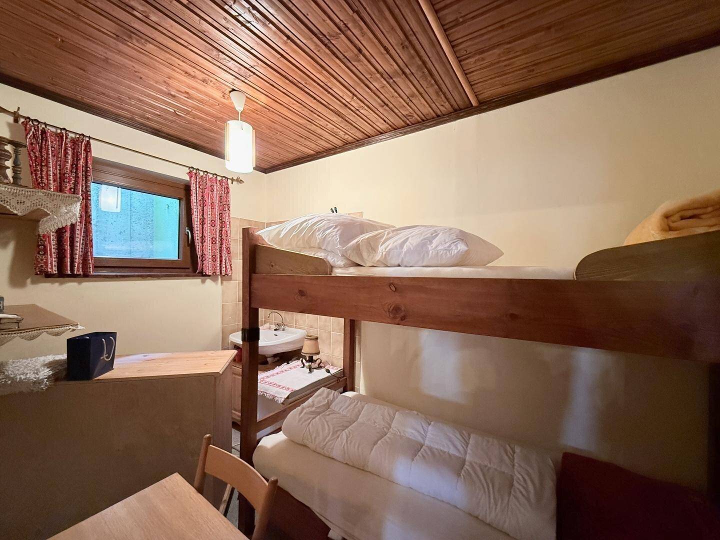 Kleines Schlafzimmer mit Etagenbett und integriertem Waschbecken, ideal für Gäste.