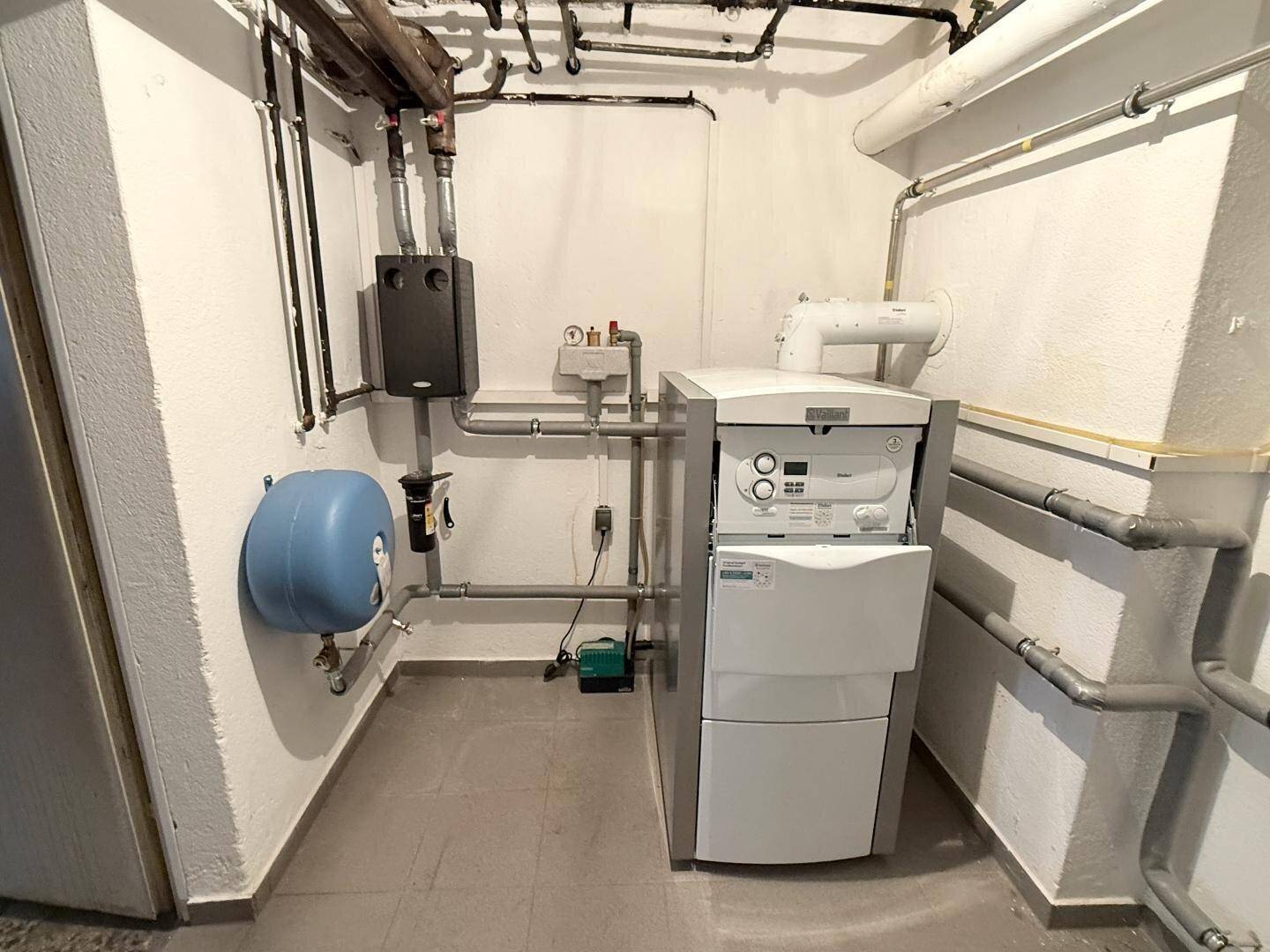Heizungsraum mit moderner Heizungsanlage und sichtbaren Rohren.