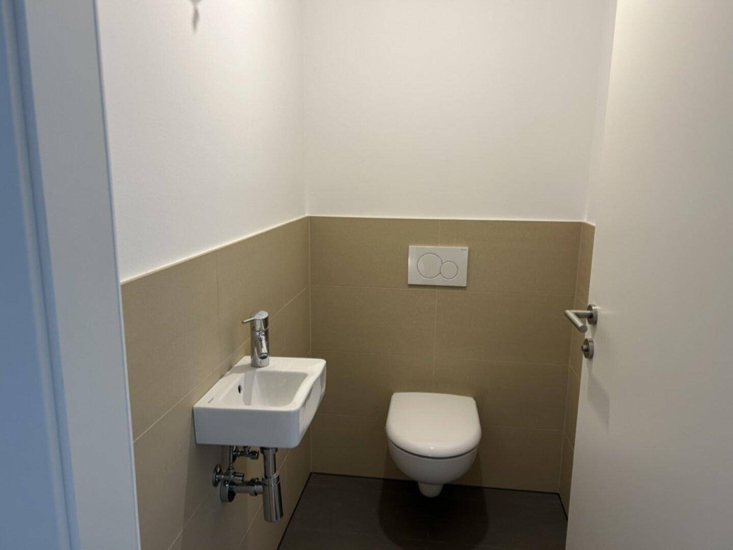Kleines Gäste-WC mit wandhängender Toilette und kompaktem Waschbecken.