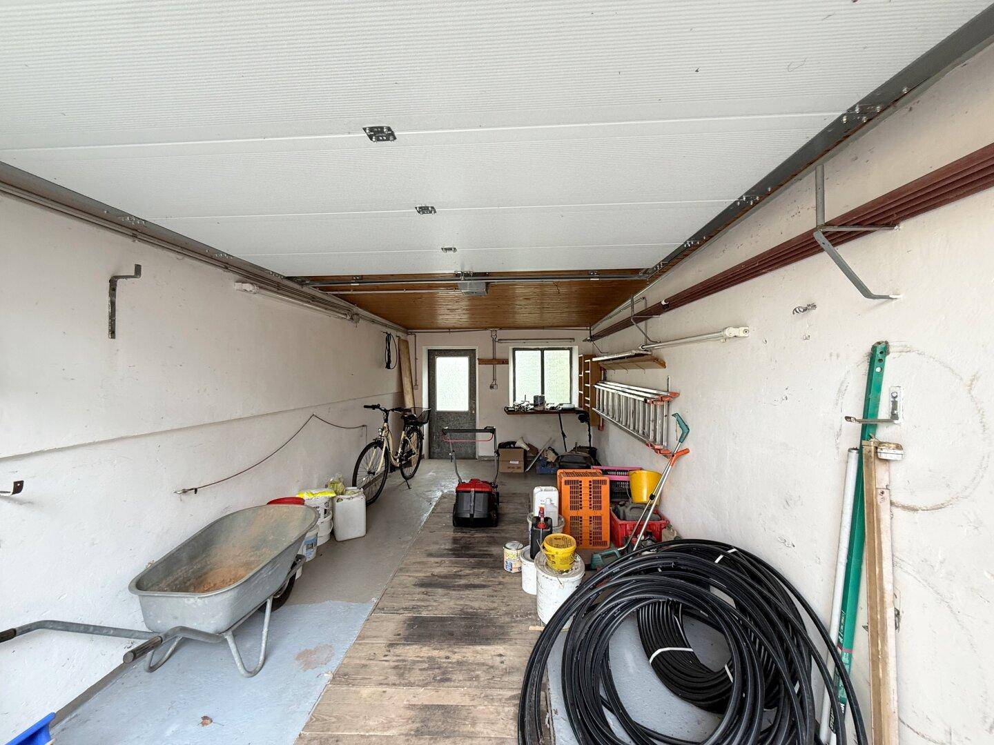 Geräumige Garage mit Lagerfläche, Werkzeugen und Fahrrädern, gut organisiert.