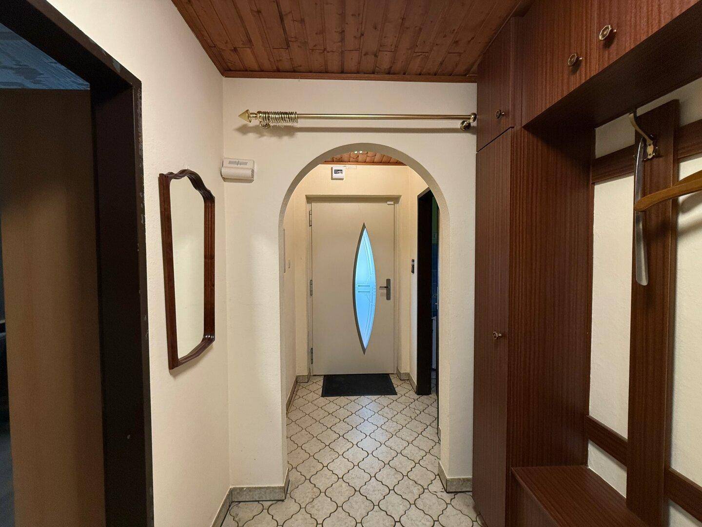 Eingangsbereich mit Holzdecke, gemustertem Fliesenboden und integriertem Garderobenschrank.