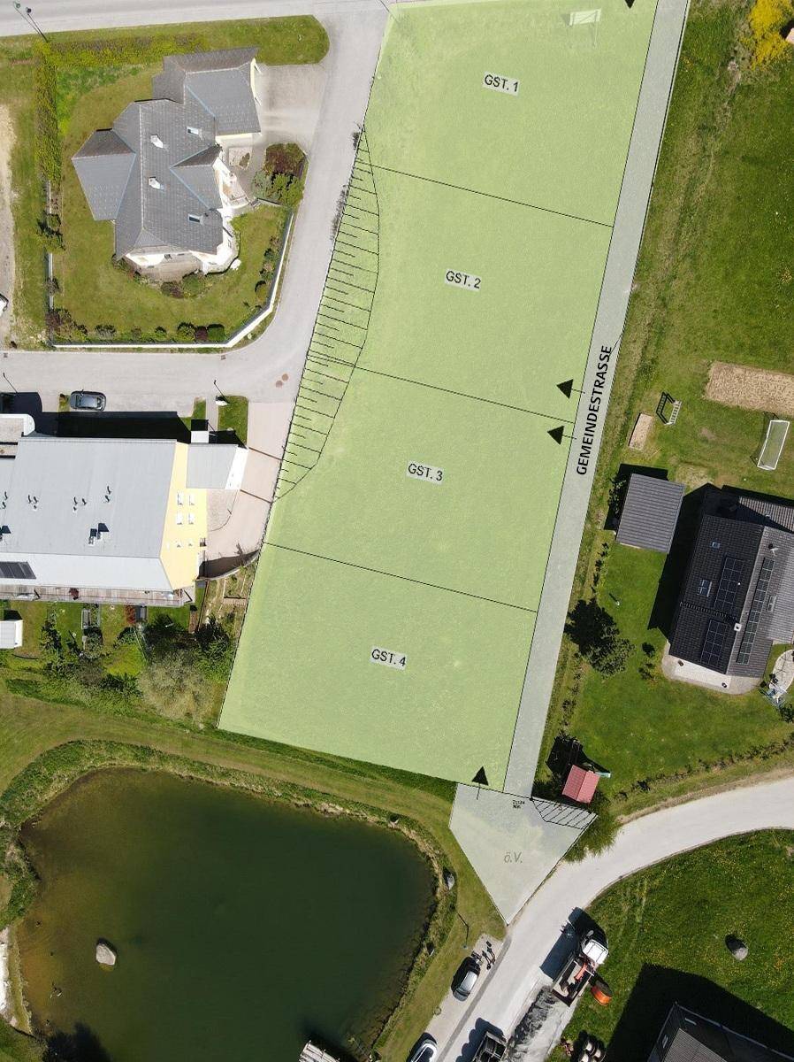 Luftbild mit überlagertem Grundstücksplan, der vier Parzellen, eine Gemeindestraße und einen Teich zeigt.
