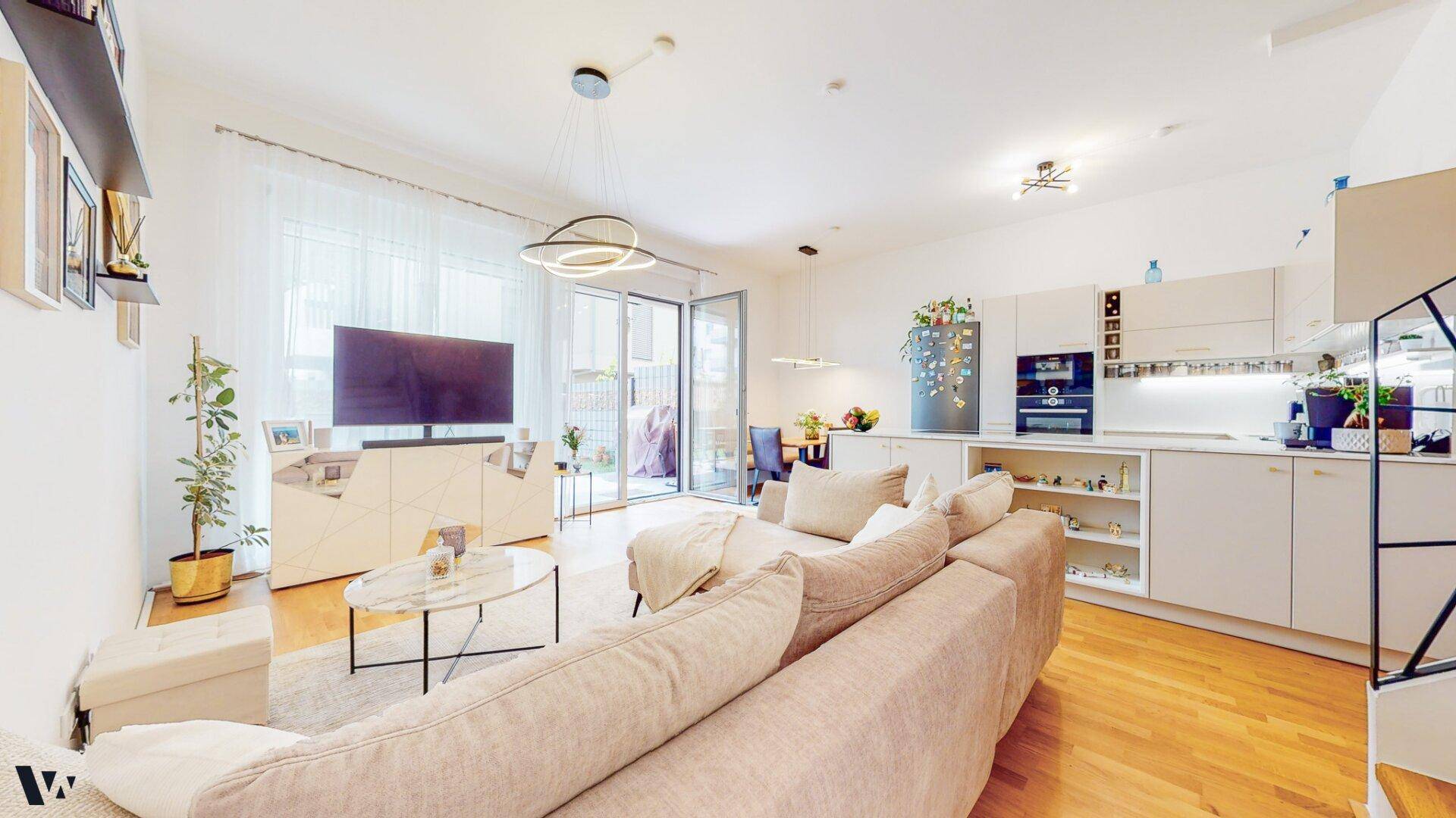 Offener Wohn- und Essbereich mit integrierter Küche, modernem Design und Zugang zur Terrasse.