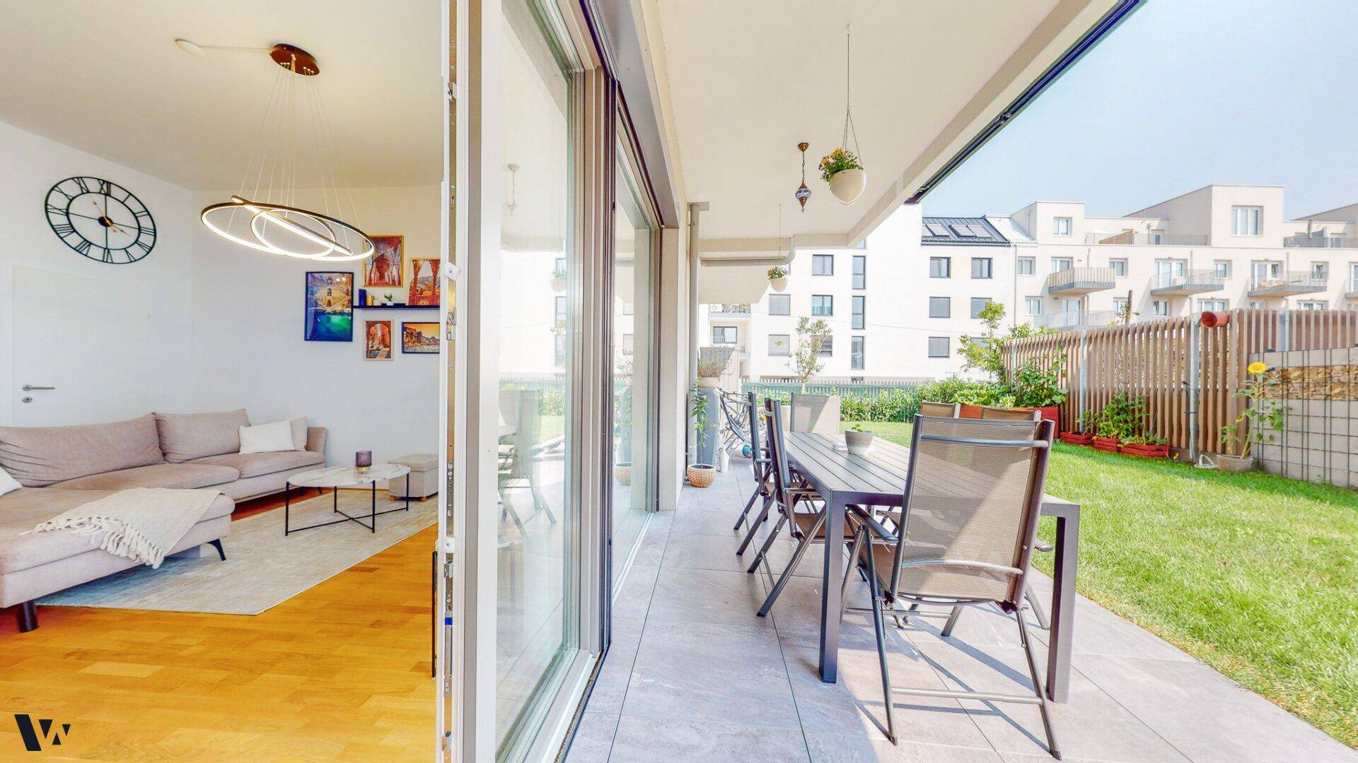 Heller Wohnbereich mit Zugang zur Terrasse, ausgestattet mit modernen Möbeln und Holzboden.