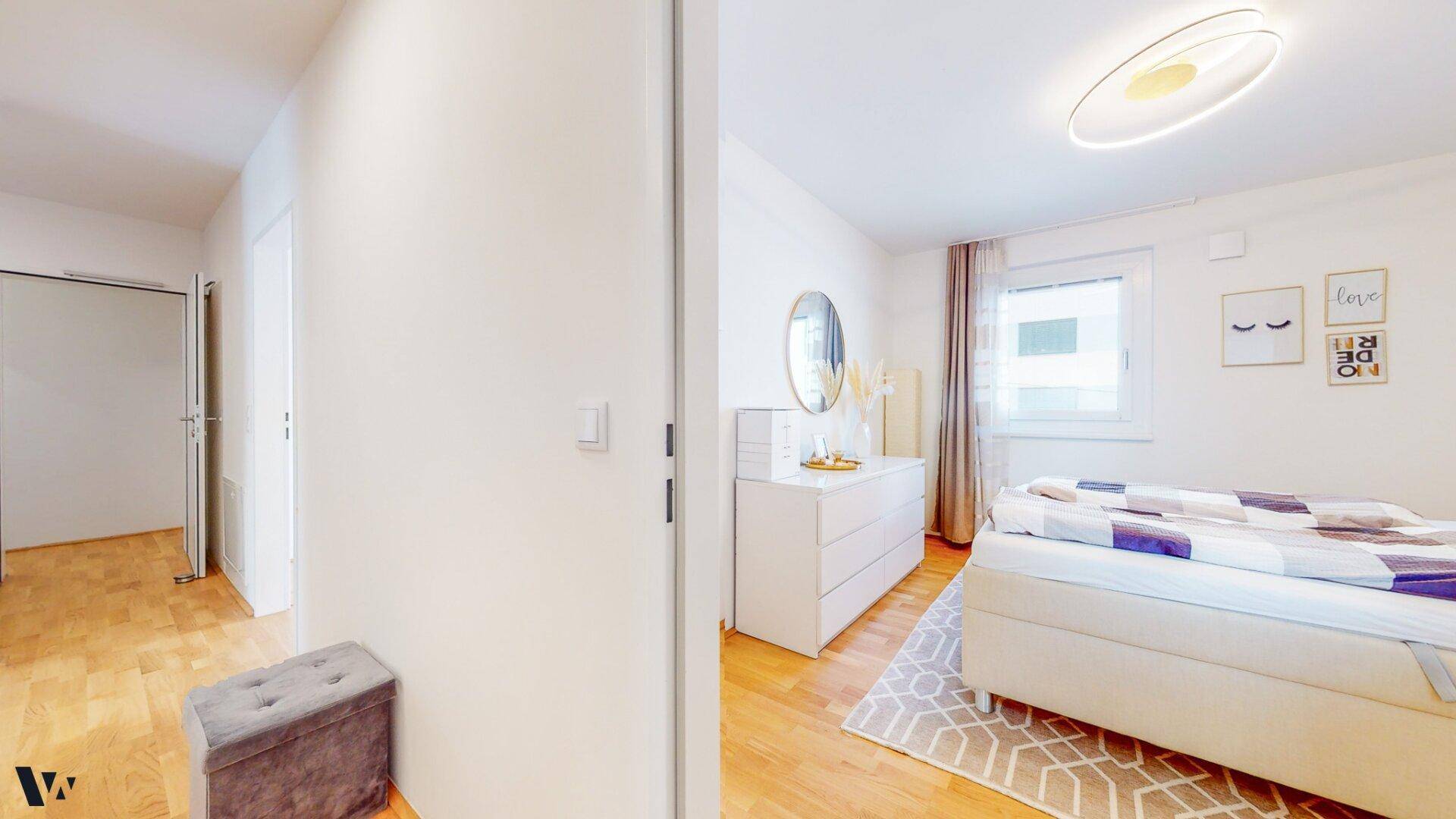 Helles Schlafzimmer mit Holzboden, modernem Bett und Fenster für viel Tageslicht.