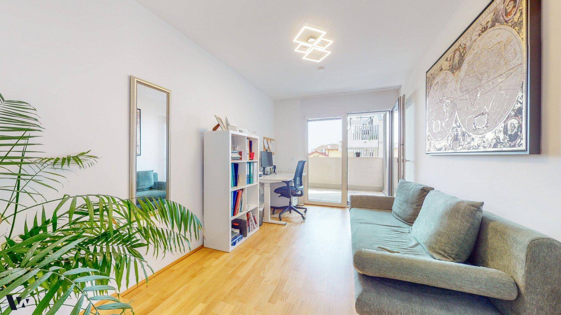 Funktionaler Büroraum mit Schreibtisch, Regal und Sofa, mit Zugang zum Balkon.
