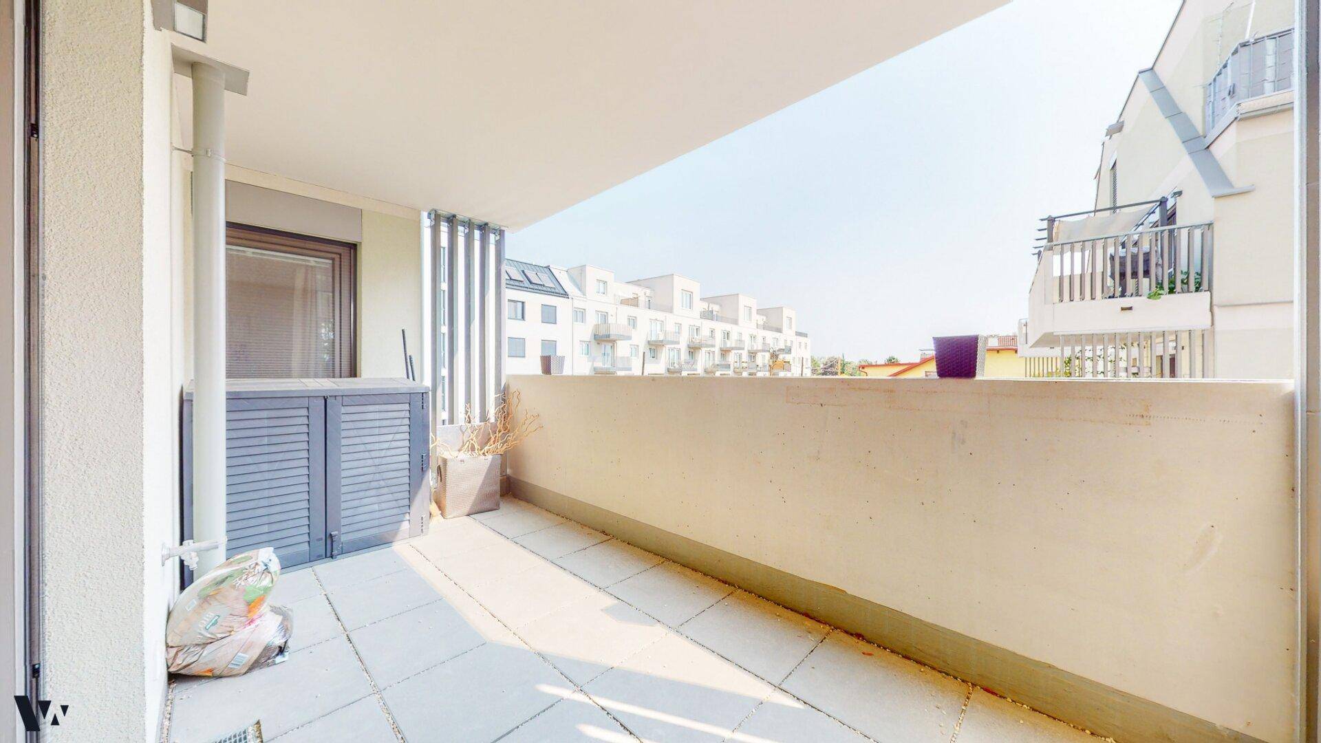 Geräumiger Balkon mit Blick auf die umliegenden Gebäude und viel Sonnenlicht.
