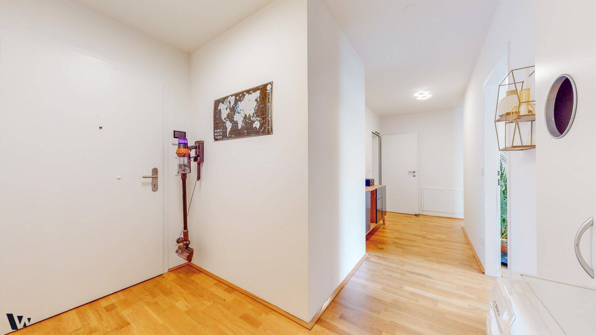 Heller Eingangsbereich mit Holzboden und moderner Dekoration an der Wand.