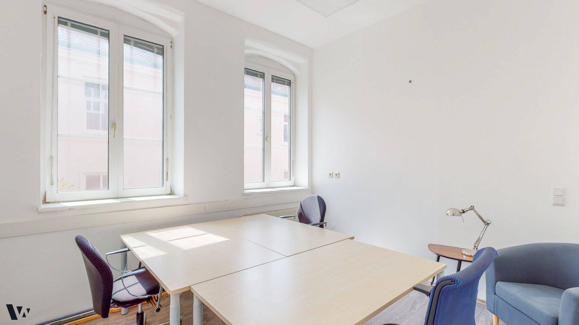 Geräumiges Büro mit Holzdielenboden, mehreren Schreibtischen und Stühlen, ideal für Teamarbeit.