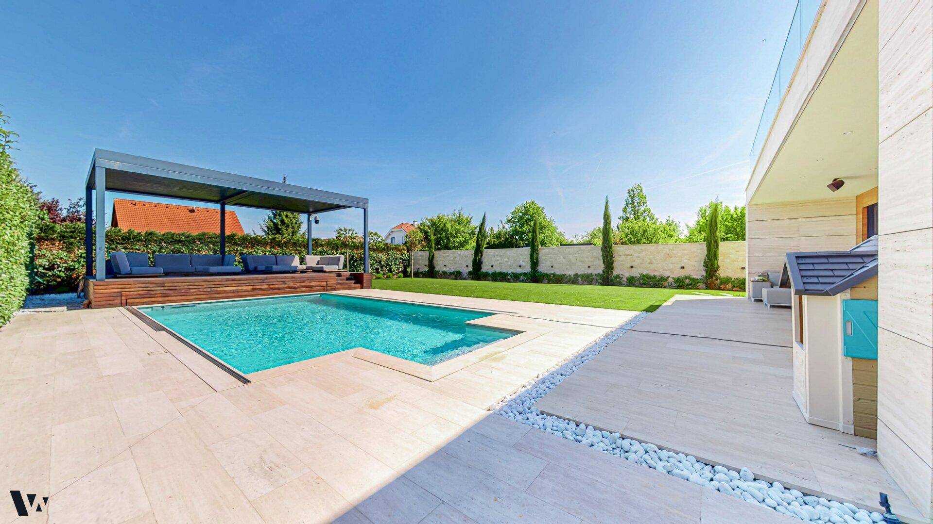 Großzügiger Außenbereich mit modernem Pool, weitläufiger Rasenfläche und eleganter Steinterrasse.