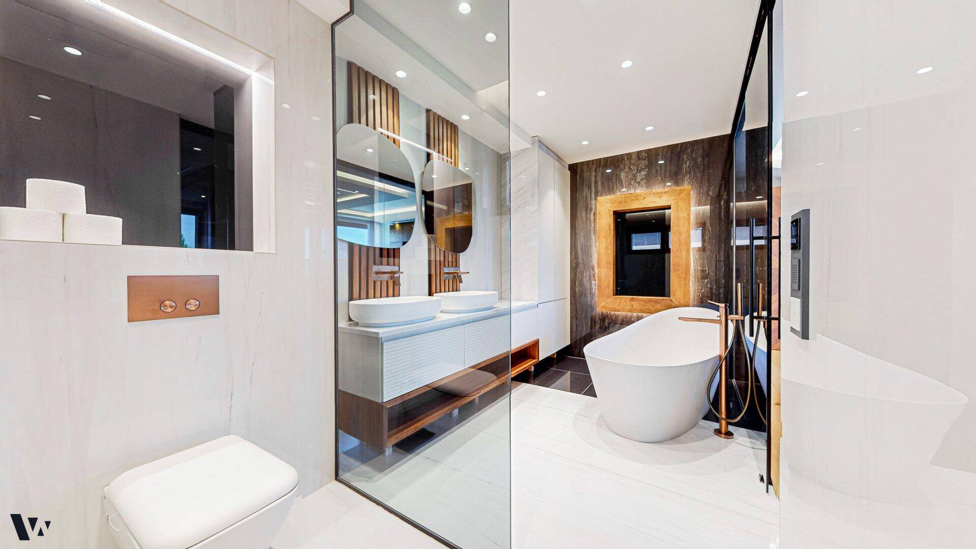 Luxuriöses Badezimmer mit freistehender Badewanne, Doppelwaschbecken und modernen Armaturen.