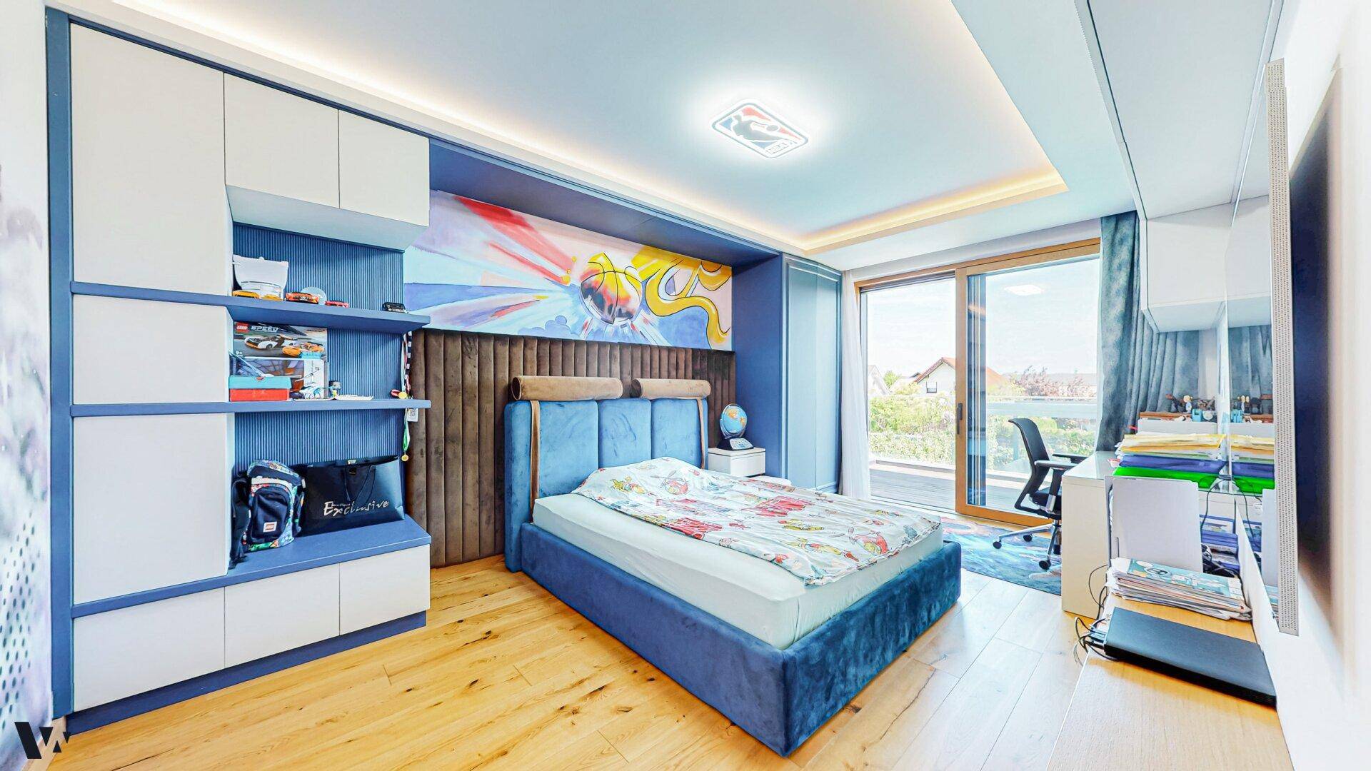 Modernes Kinderzimmer mit blauem Bett, Schreibtisch und Zugang zu einem Balkon.