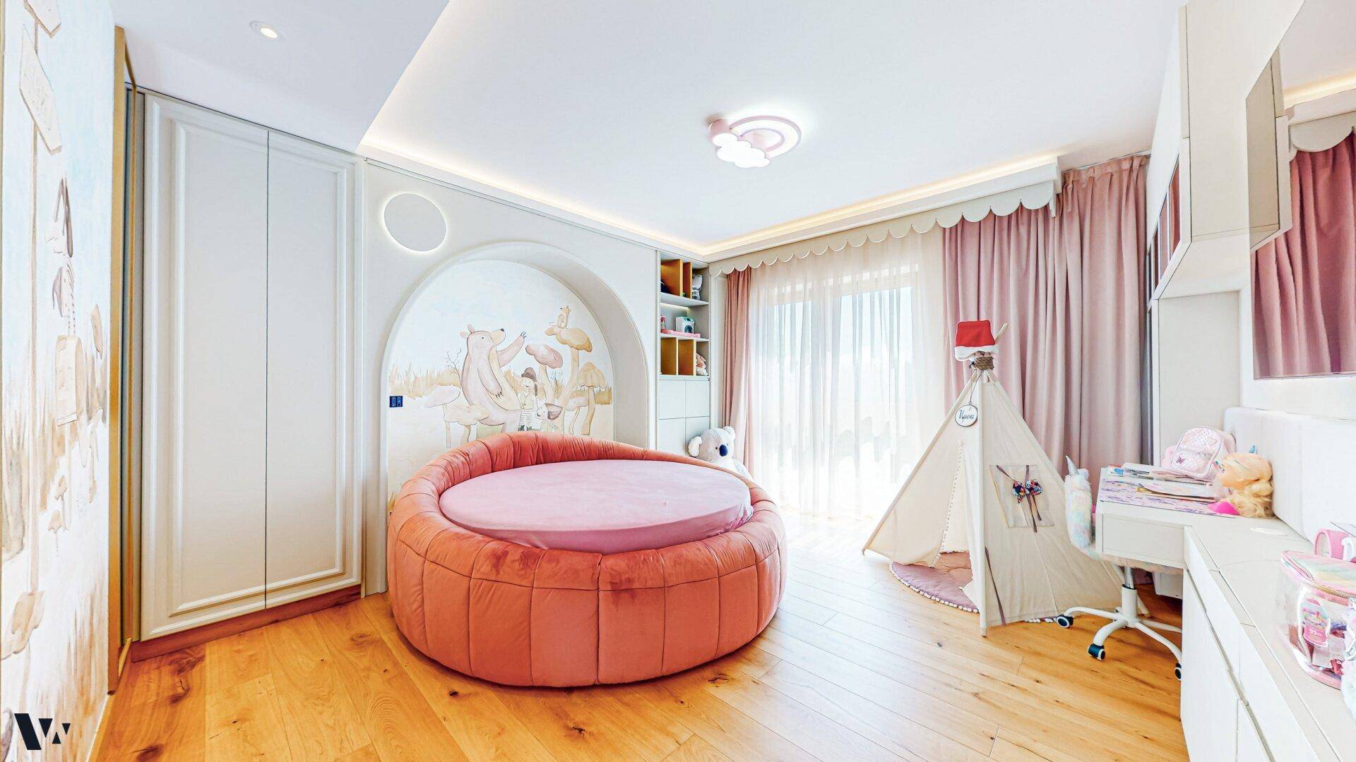 Charmantes Kinderzimmer mit rundem Bett, Spielzelt und verspielter Wandgestaltung in Pastelltönen.