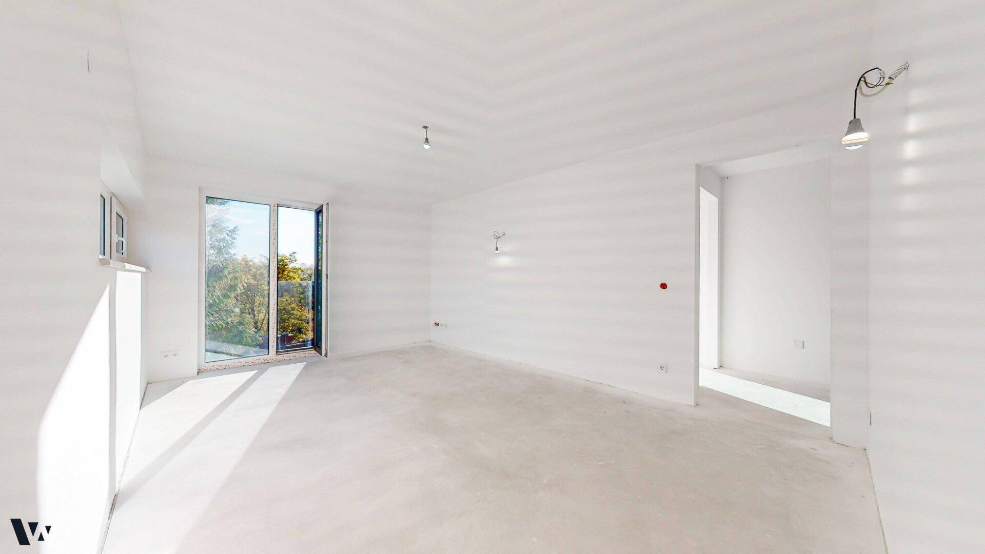 Geräumiger, heller Raum im Rohbau mit großen Fenstern und viel Potenzial zur individuellen Gestaltung.