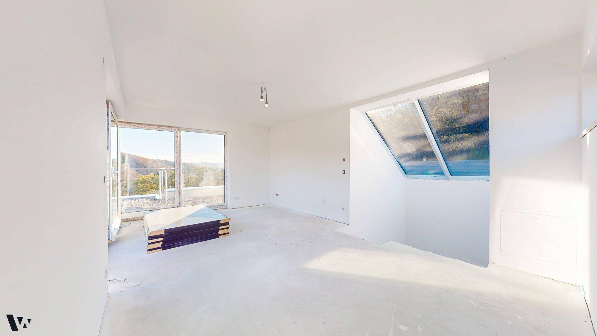 Heller, unfertiger Raum mit großen Schiebetüren und Dachfenster, bietet viel Tageslicht und Ausblick.