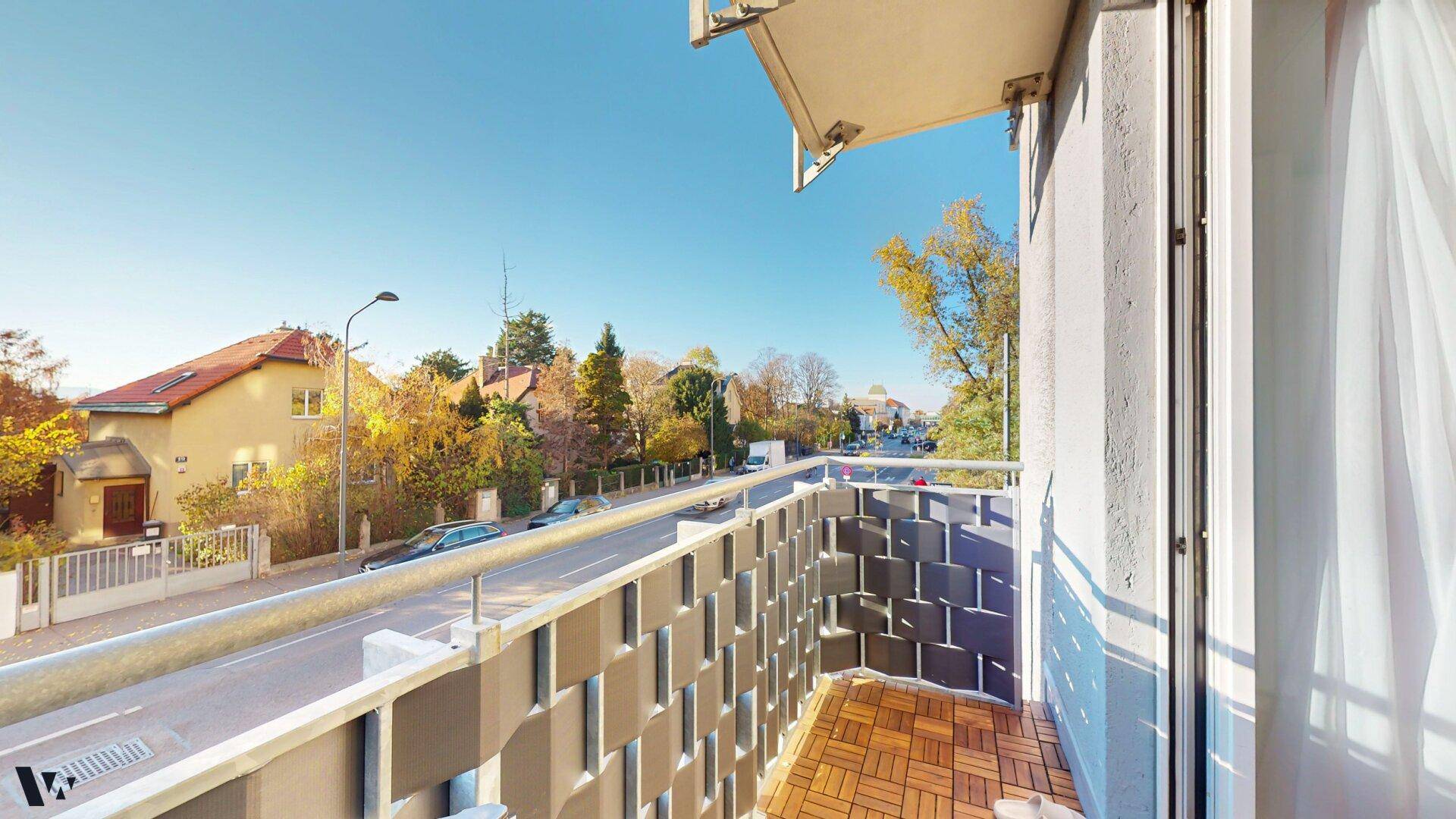 Geräumiger Balkon mit Holzboden und weitem Blick über die Wohngegend.