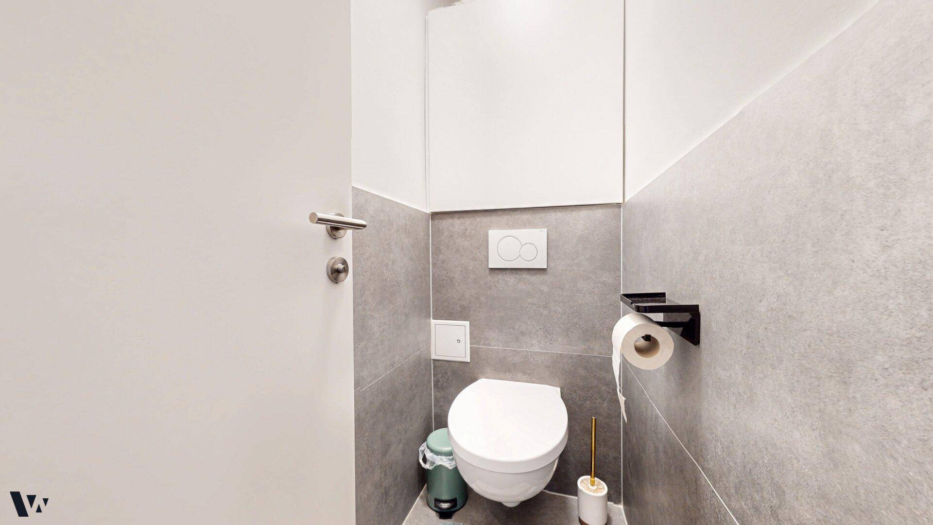 Kleines Gäste-WC mit Wand-WC und modernen grauen Fliesen.