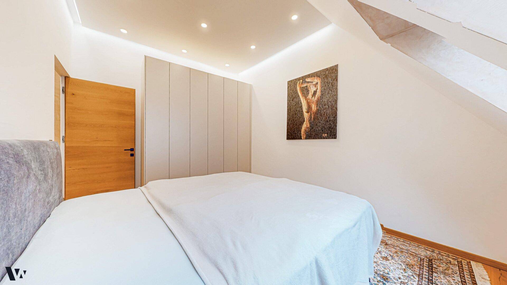 Modernes Schlafzimmer mit komfortablem Bett und einem eleganten Einbauschrank.