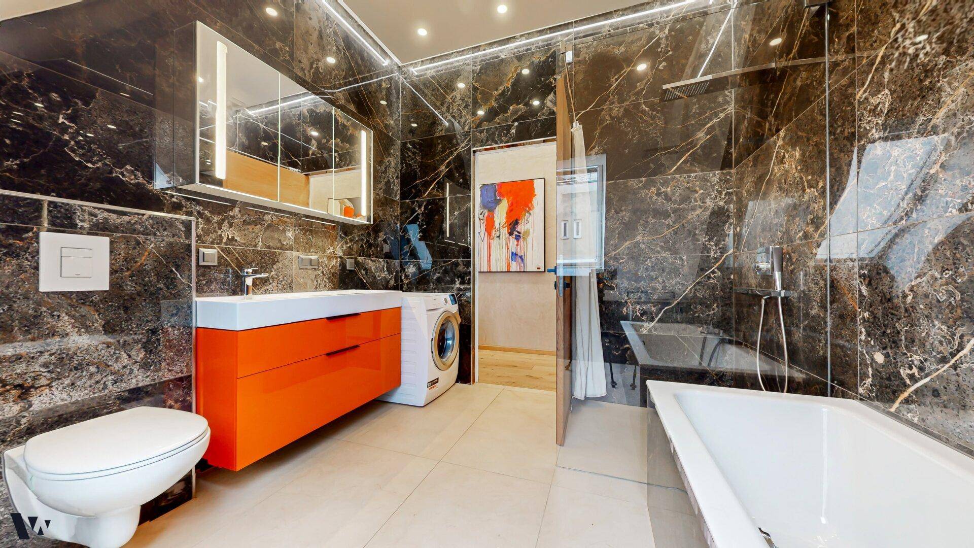 Zeitgemäßes Badezimmer mit begehbarer Dusche, wandhängendem WC und Waschmaschine.