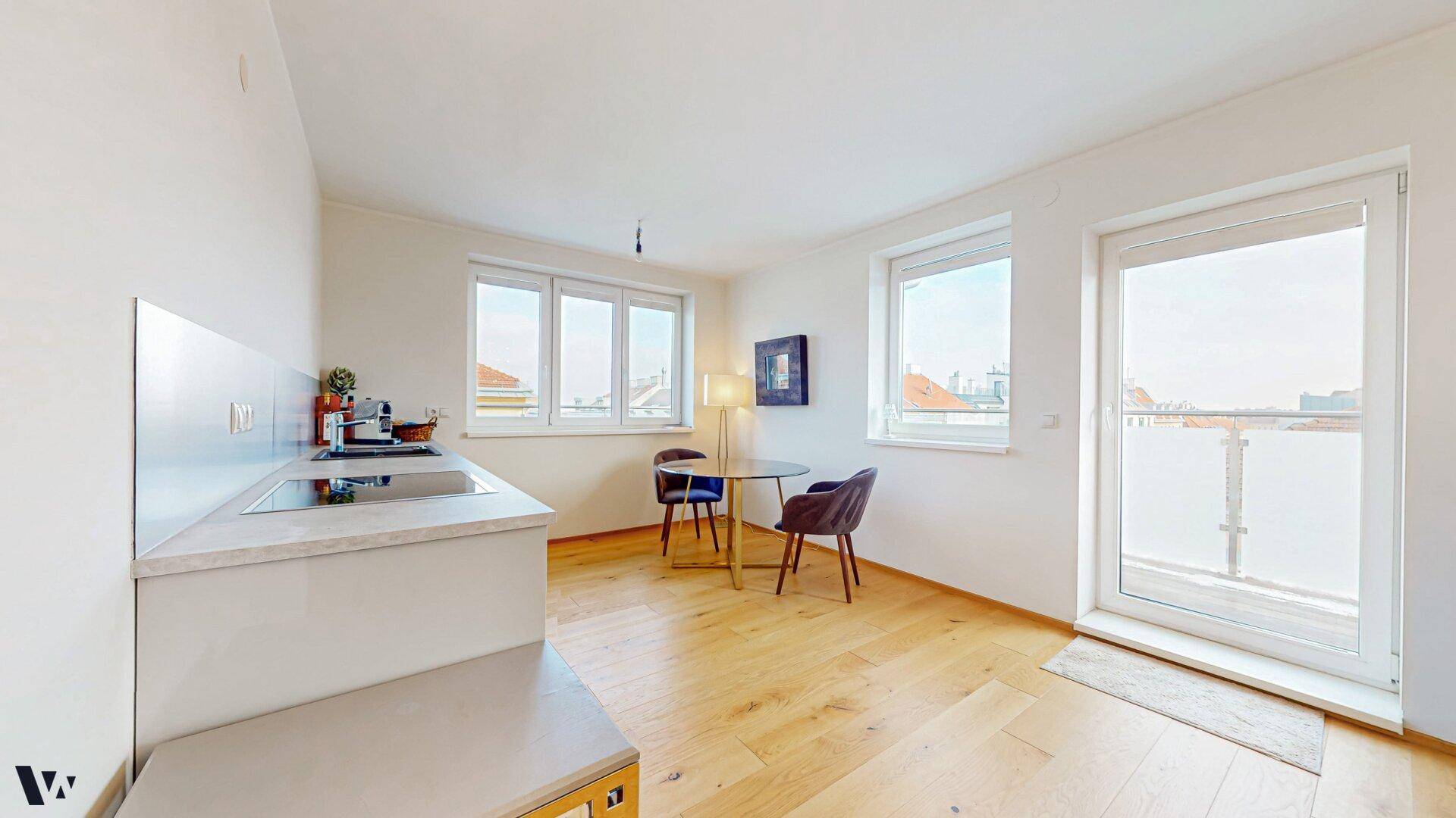 Kompakte Küchenzeile mit Essbereich und Zugang zum Balkon, ideal für kleine Mahlzeiten.