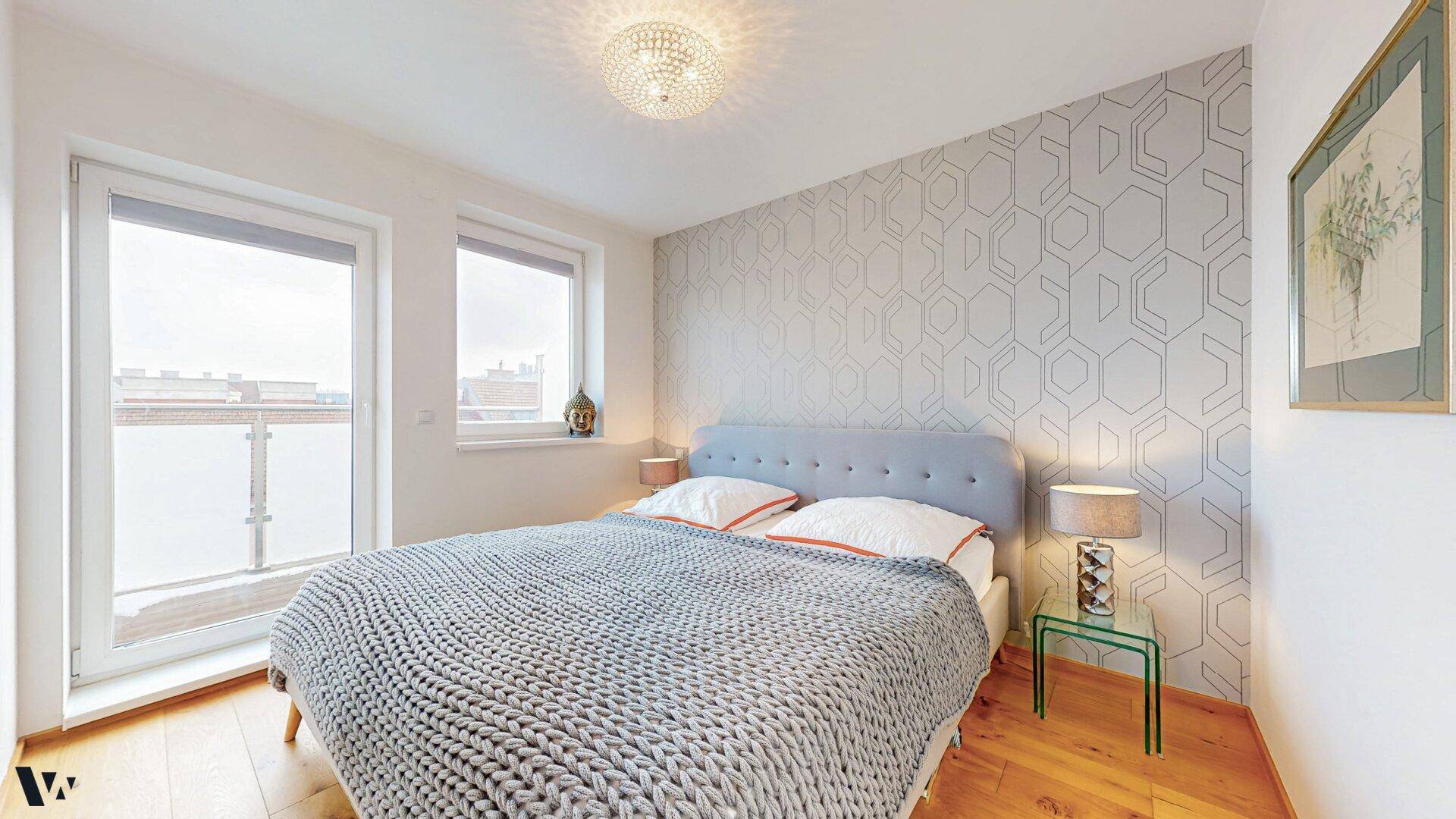 Gemütliches Schlafzimmer mit modernem Muster an der Wand und viel Tageslicht durch die Fenster.