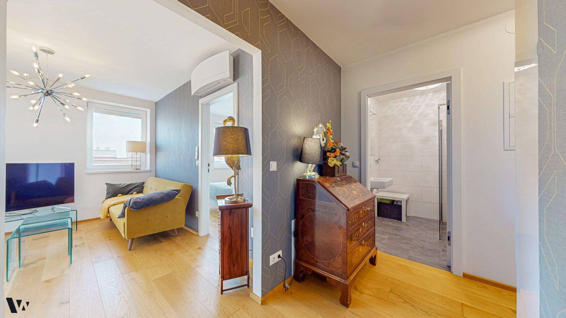 Flur mit elegantem Holzschrank und Zugang zum Wohnbereich sowie zum Badezimmer.