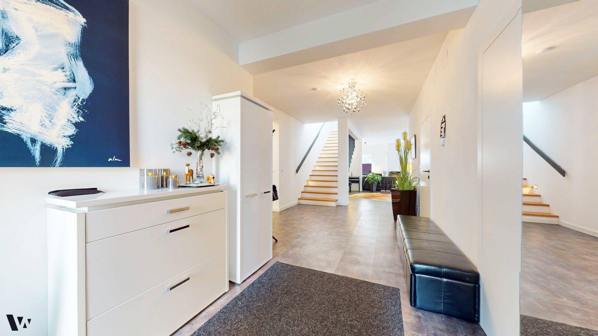 Heller Eingangsbereich mit Garderobe, Sitzbank und Treppenzugang zum Obergeschoss.
