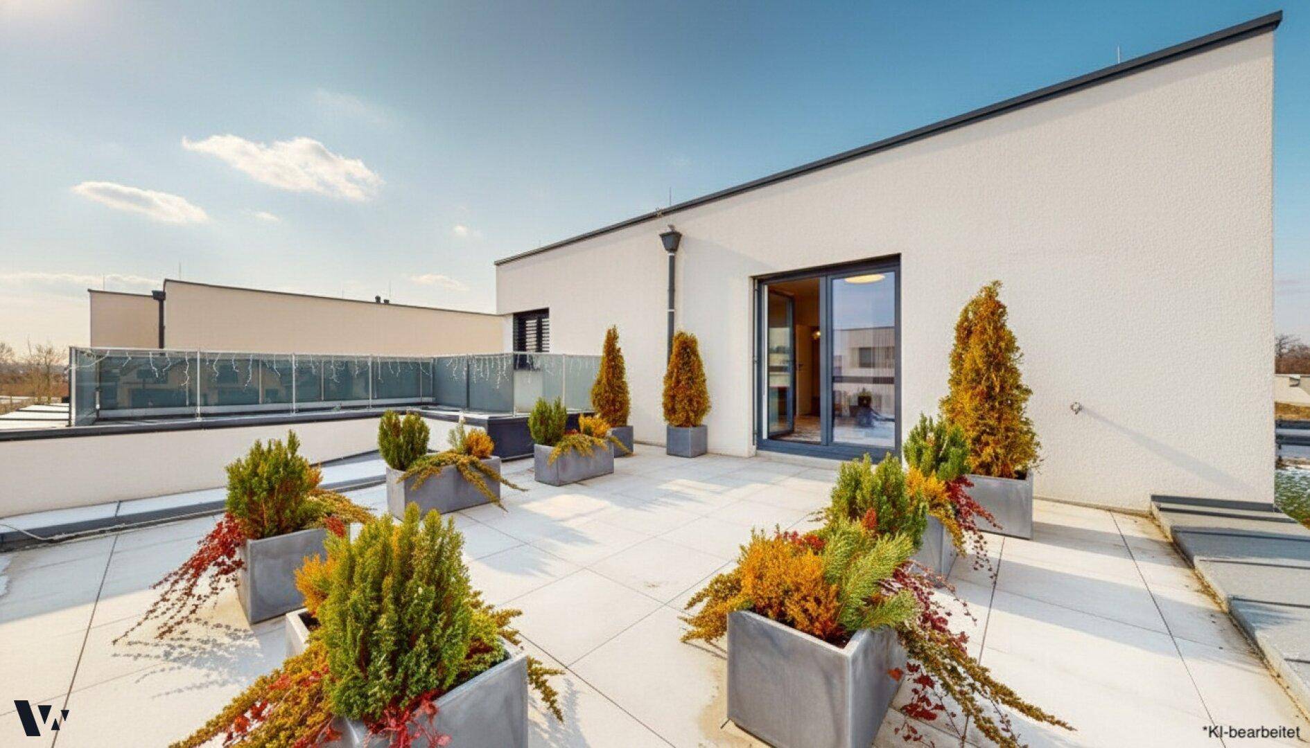 Große Dachterrasse mit Pflanzenkübeln und weitem Blick unter blauem Himmel.