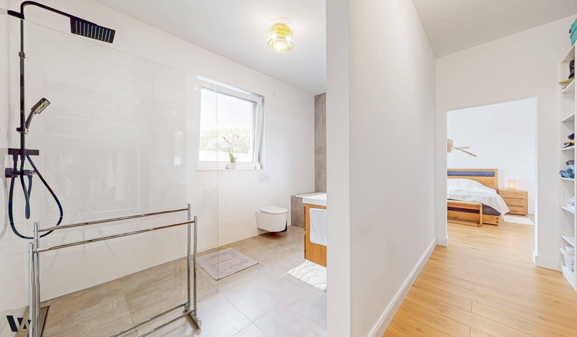 Modernes Badezimmer mit ebenerdiger Dusche, Wand-WC und Fenster für Tageslicht.