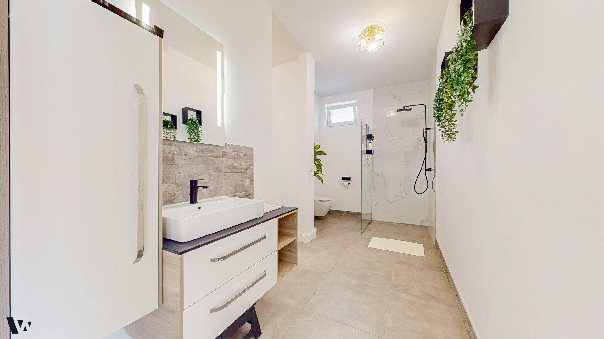 Modernes Badezimmer mit Waschtisch, Spiegelschrank und ebenerdiger Dusche.