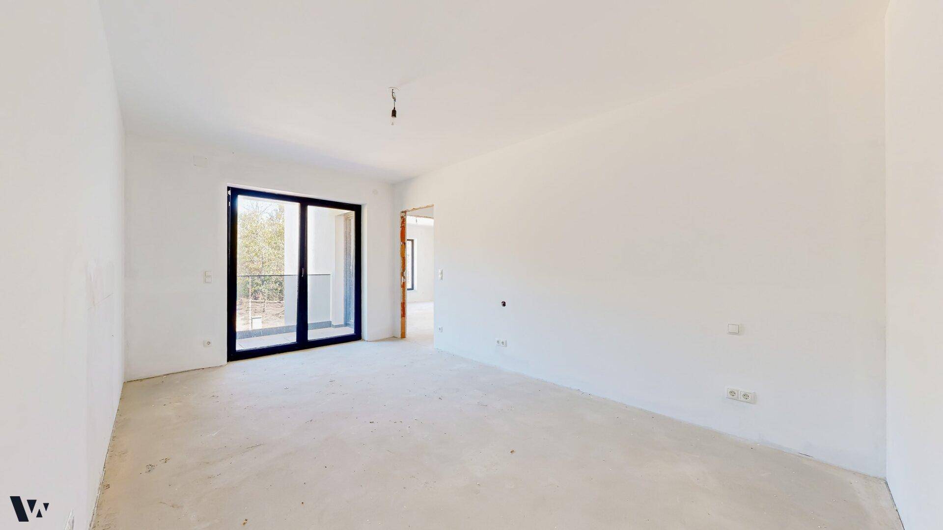 Geräumiges Zimmer im Rohbau mit Zugang zum Balkon und viel natürlichem Licht.