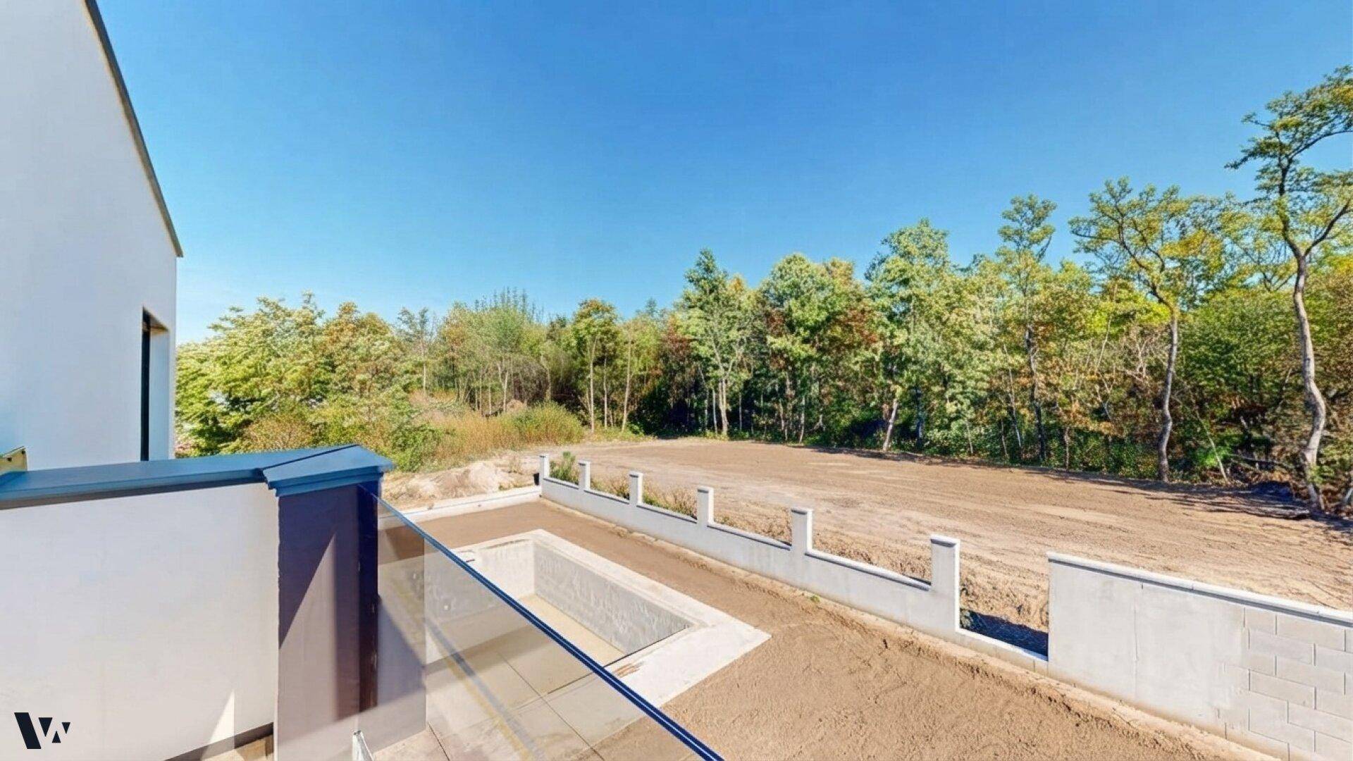 Weitläufiger Blick vom Balkon auf die unberührte Natur und den Gartenbereich der Immobilie.
