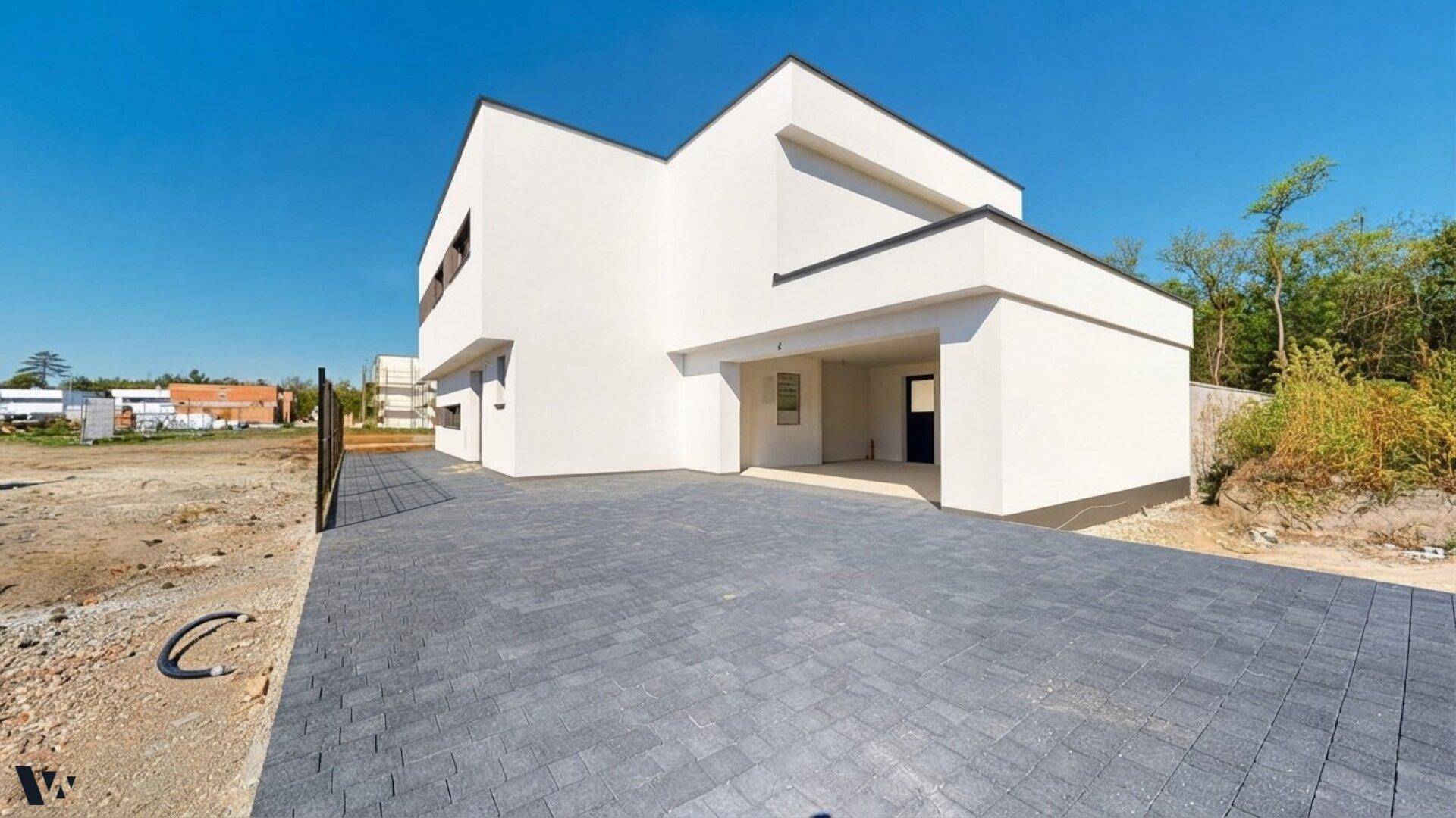 Moderne Architektur der Villa mit gepflasterter Auffahrt und umliegendem Grundstück.