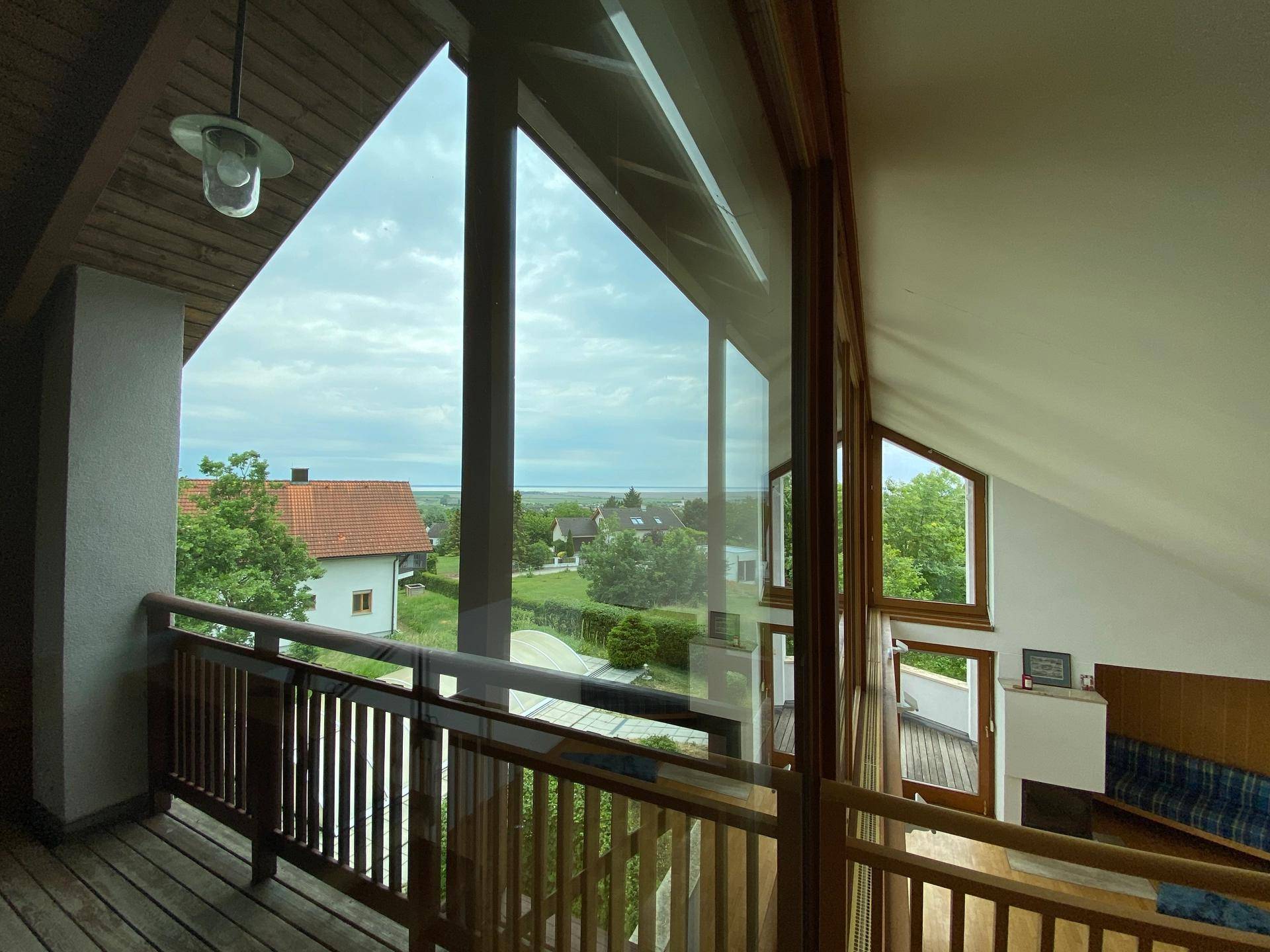 Heller Innenbereich mit großen Fenstern, die einen weiten Blick über die Landschaft und das Wasser bieten.