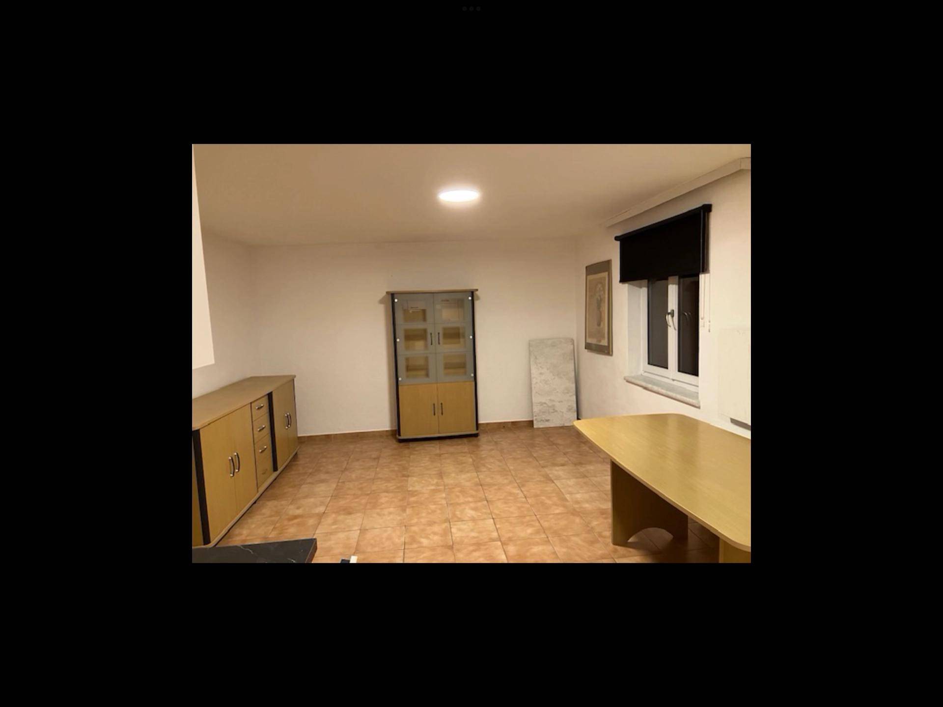 Heller Flur mit Fliesenboden, der von der Küche zu weiteren Räumen führt.