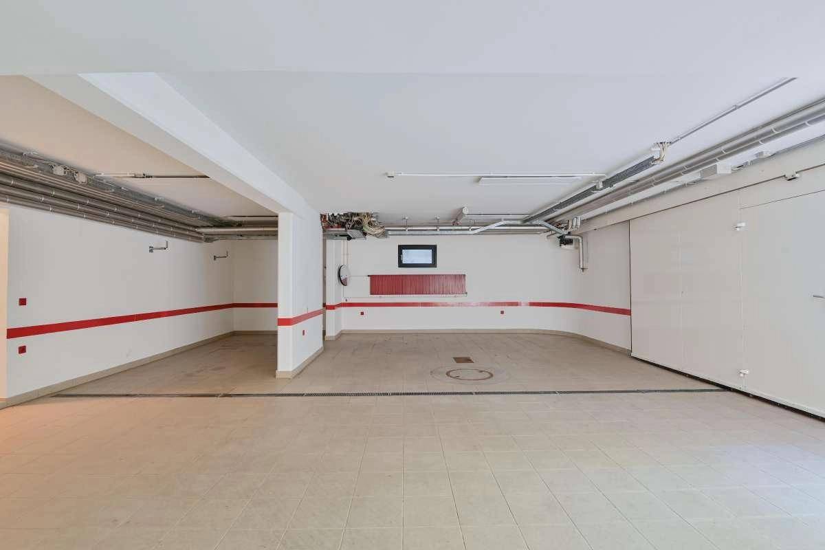 Geräumige und saubere Garage mit Fliesenboden, bereit für mehrere Fahrzeuge.