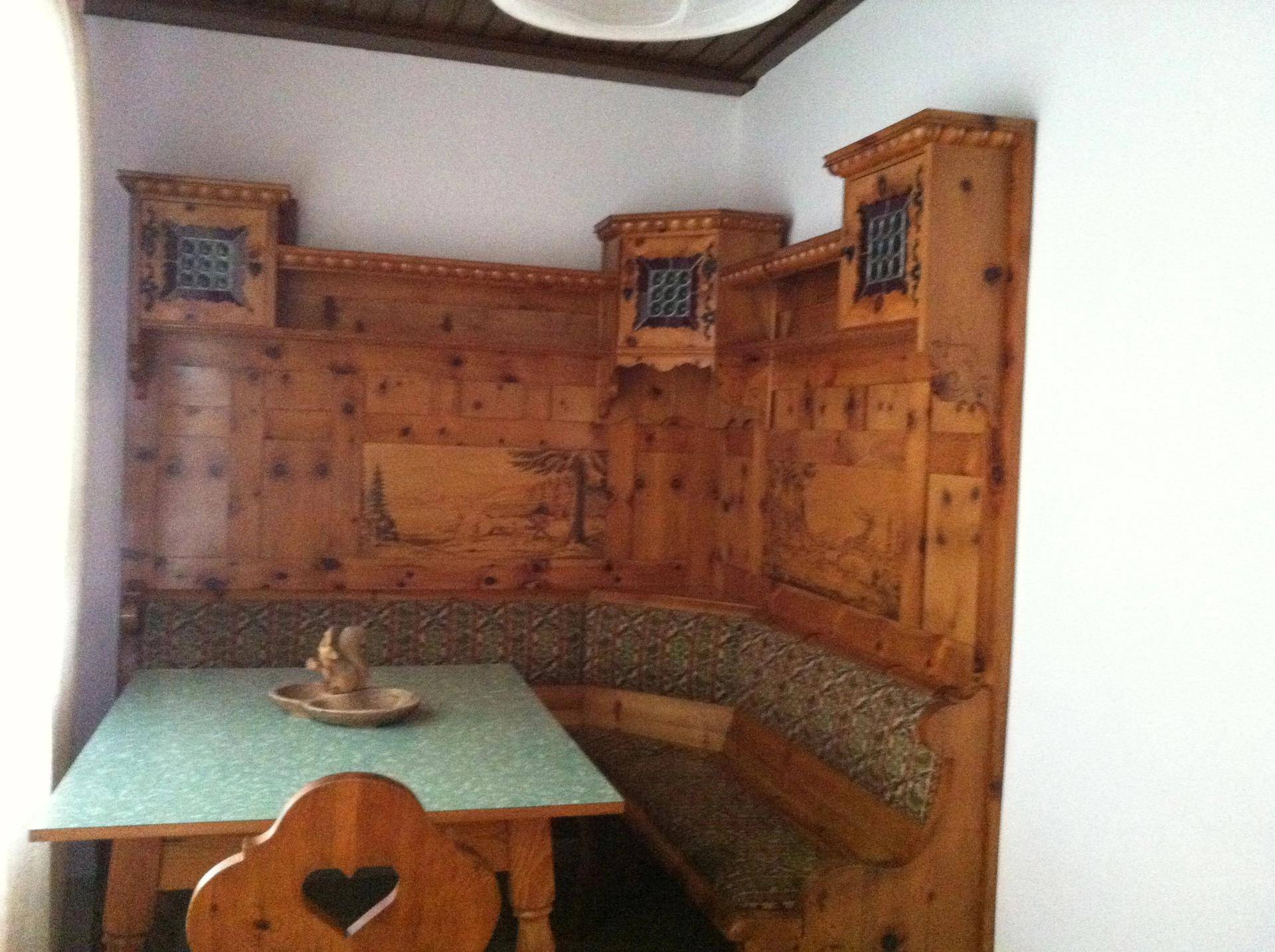 Traditionelle Essecke mit aufwendiger Holzvertäfelung und Eckbank.