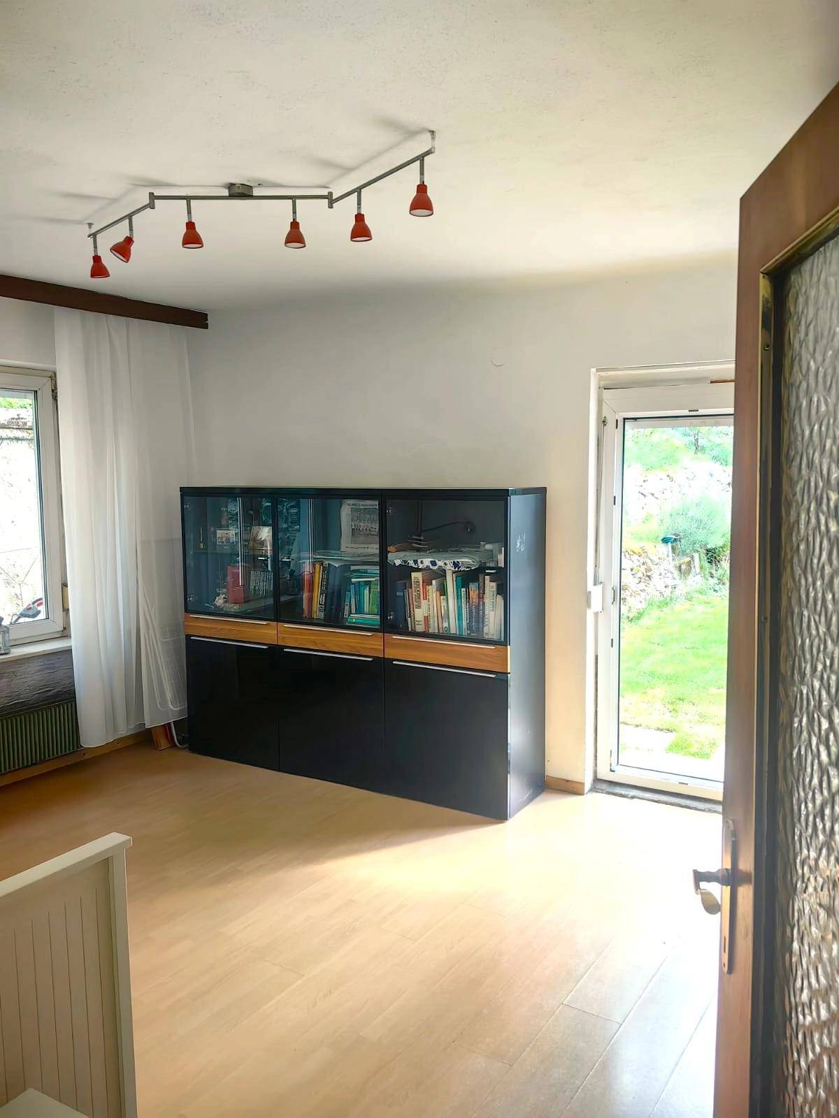Moderne Küche mit hellen Schränken, Holzarbeitsplatten und integrierten Geräten.