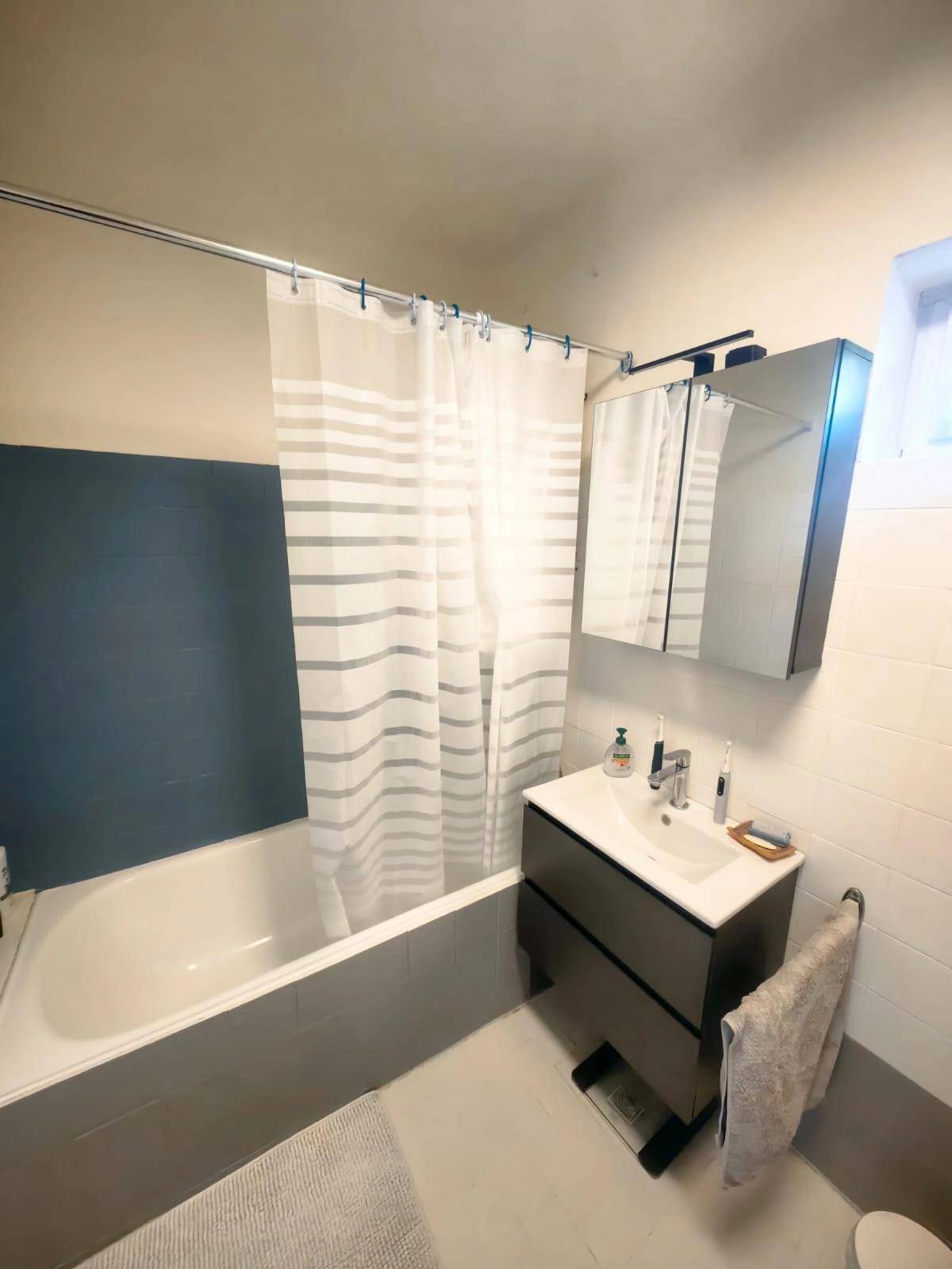 Separates WC mit Toilette, Waschmaschine und Heizkörper.