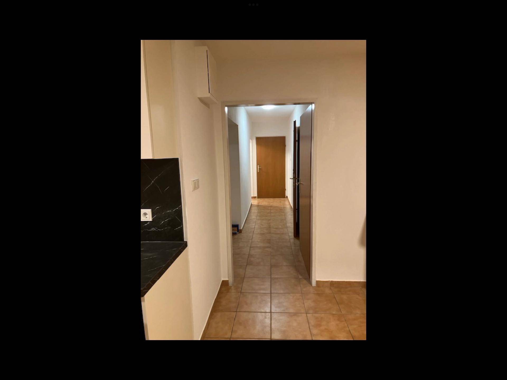 Leeres Zimmer mit Holzfußboden, Fenster und Heizkörper, ideal als Schlaf- oder Arbeitszimmer.