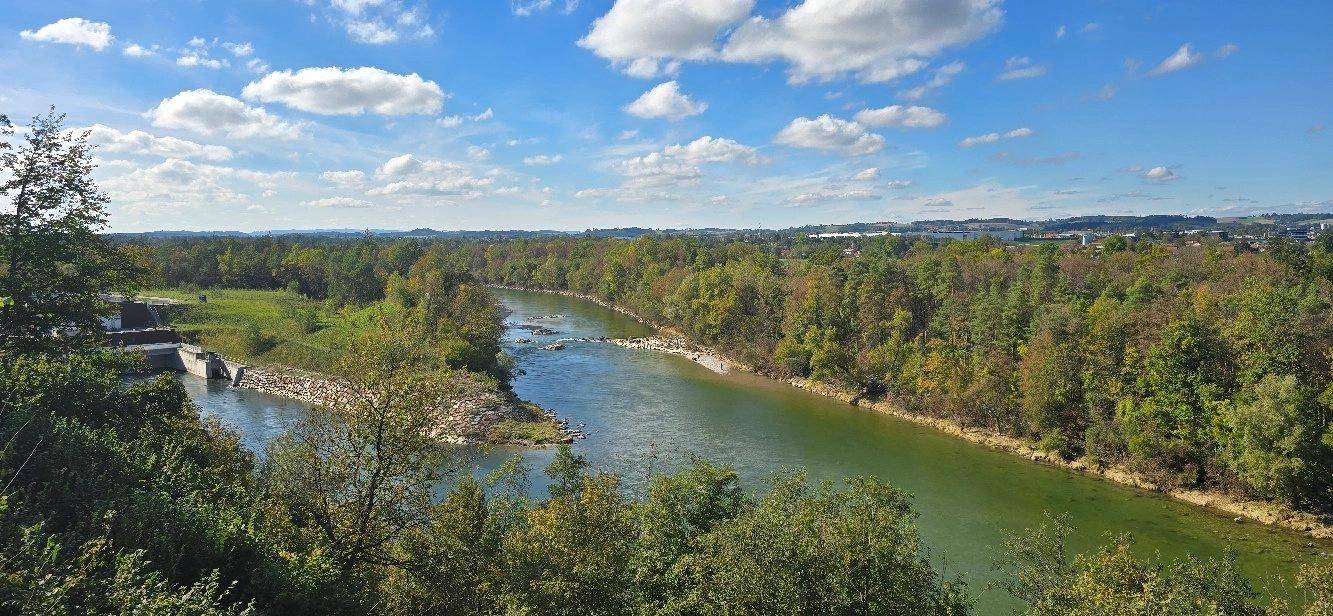 Weitläufige Flusslandschaft mit üppigen Wäldern und einem klaren blauen Himmel, ideal für Naturliebhaber.